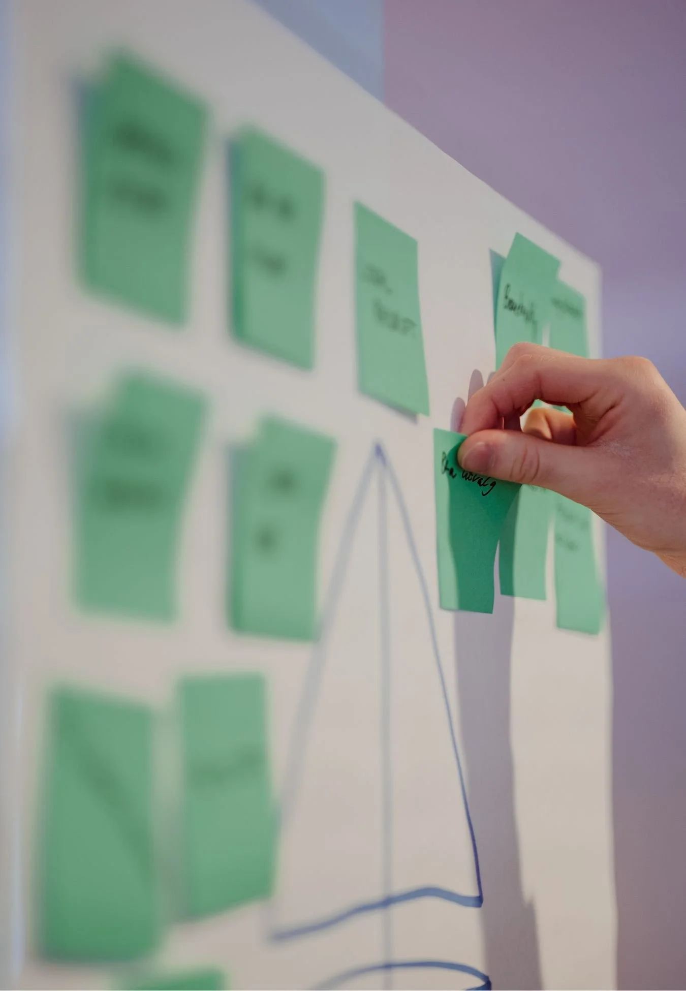 person som henger post its opp under en workshop