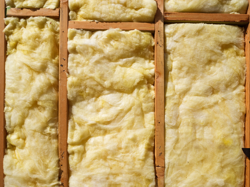 Insulation foam installed between wooden studs in a wall.