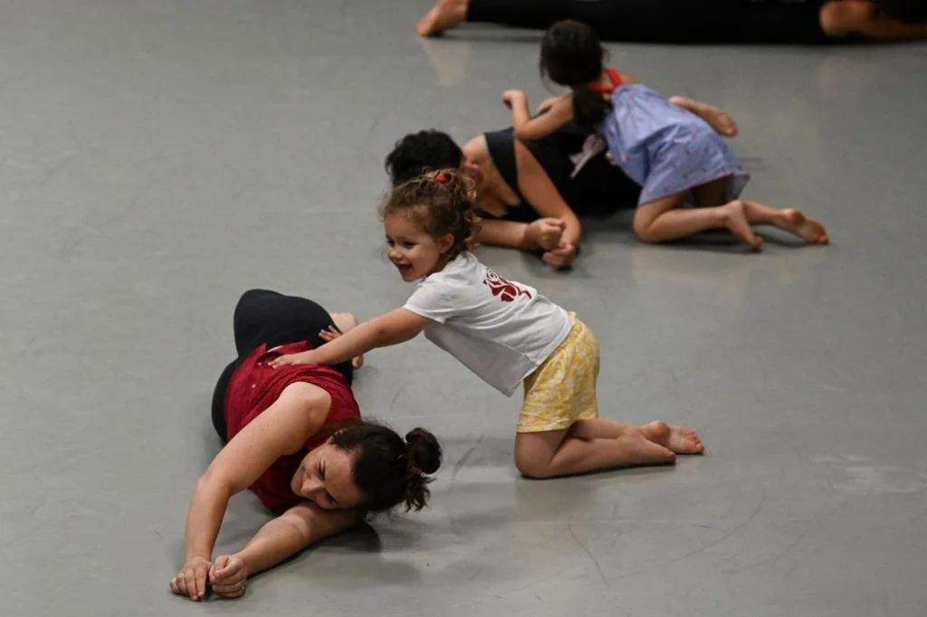 Young children practicing Brazilian jiu-jitsu on the mat with an instructor.