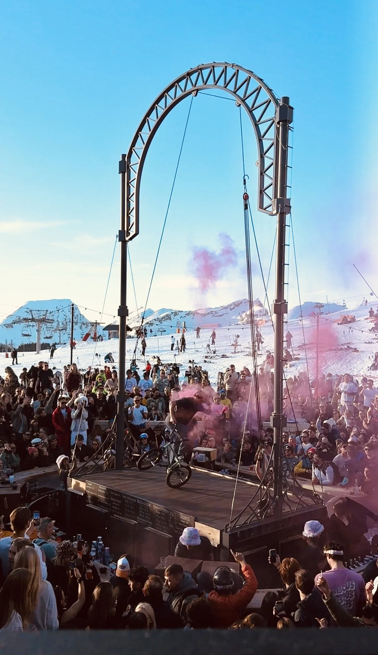 Démonstration de BMX flat sur la scène de La Folie Douce Avoriaz, au milieu d'un fumigène rose, devant la foule