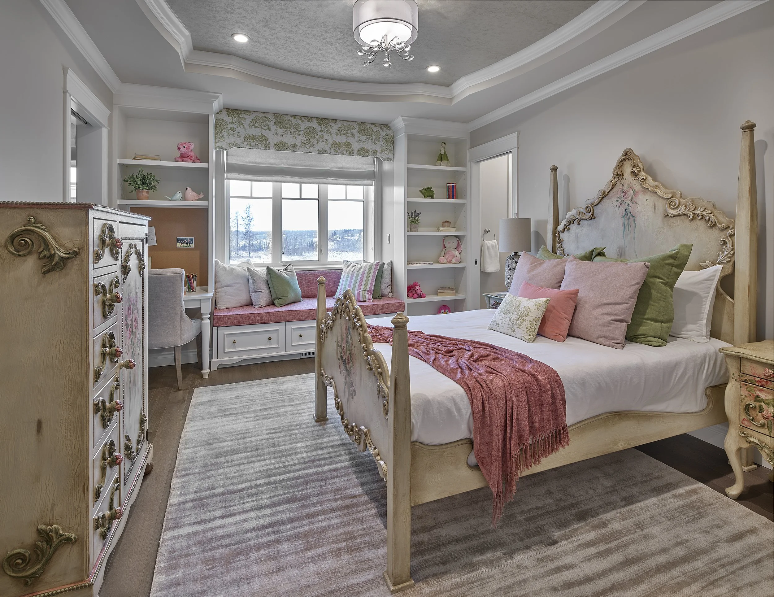 A bedroom with a vintage-style bed, multiple pillows, a window seat with pillows, built-in shelves, and decorative items, in a cozy and well-lit space.