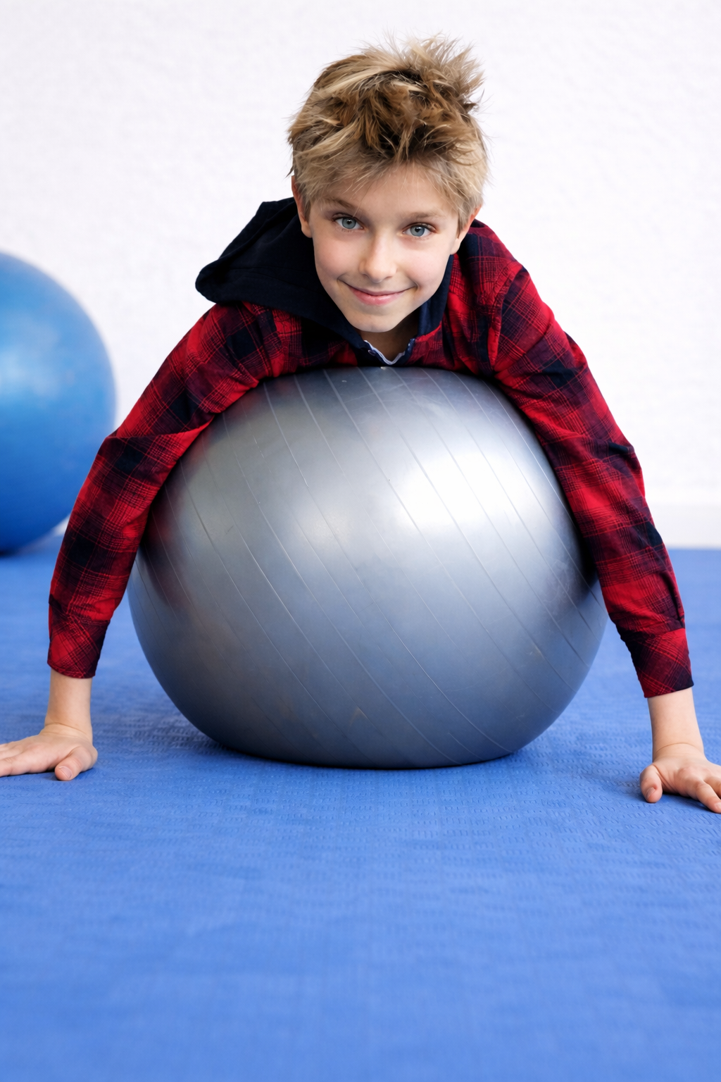Kind liggend op een grote oefenbal in een oefenruimte.