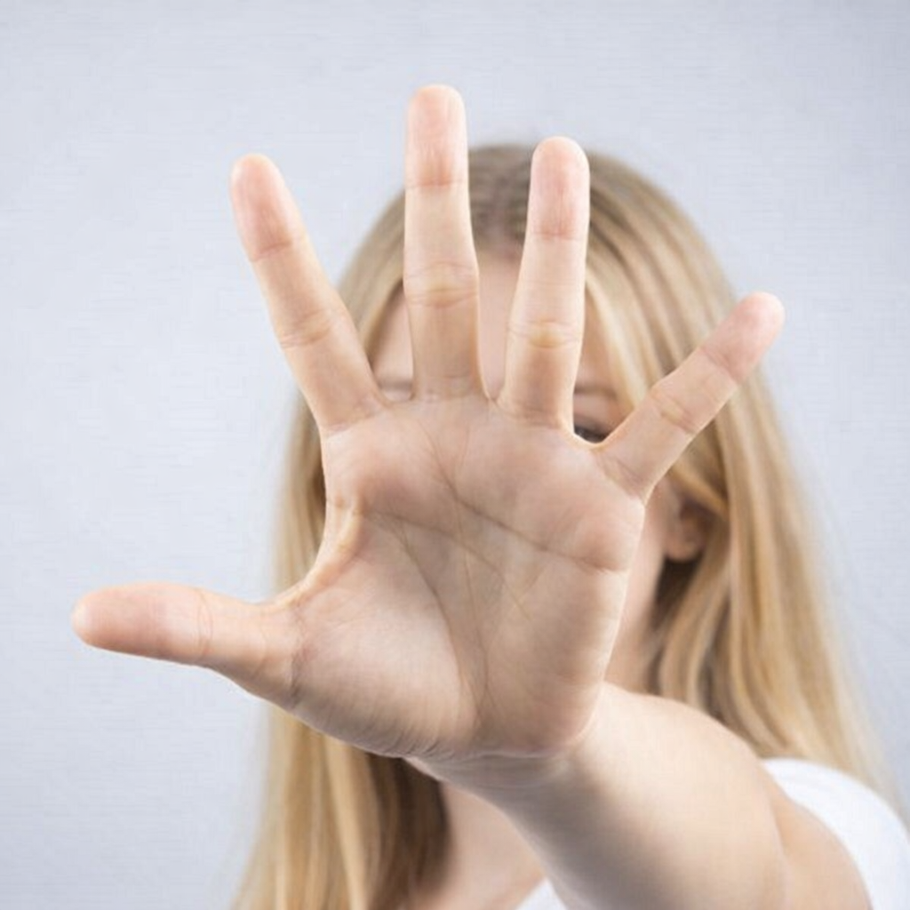 Persoon die een open hand naar voren houdt, met het gezicht onscherp op de achtergrond.