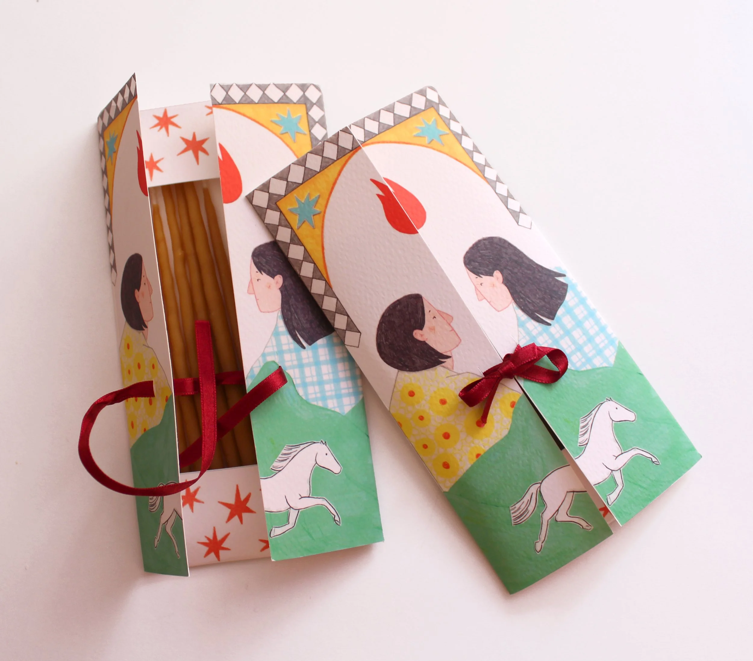 Paquete de espaguetis con envoltorio decorado con ilustraciones de una mujer y un caballo blanco con fondo de montañas y cielo azul.