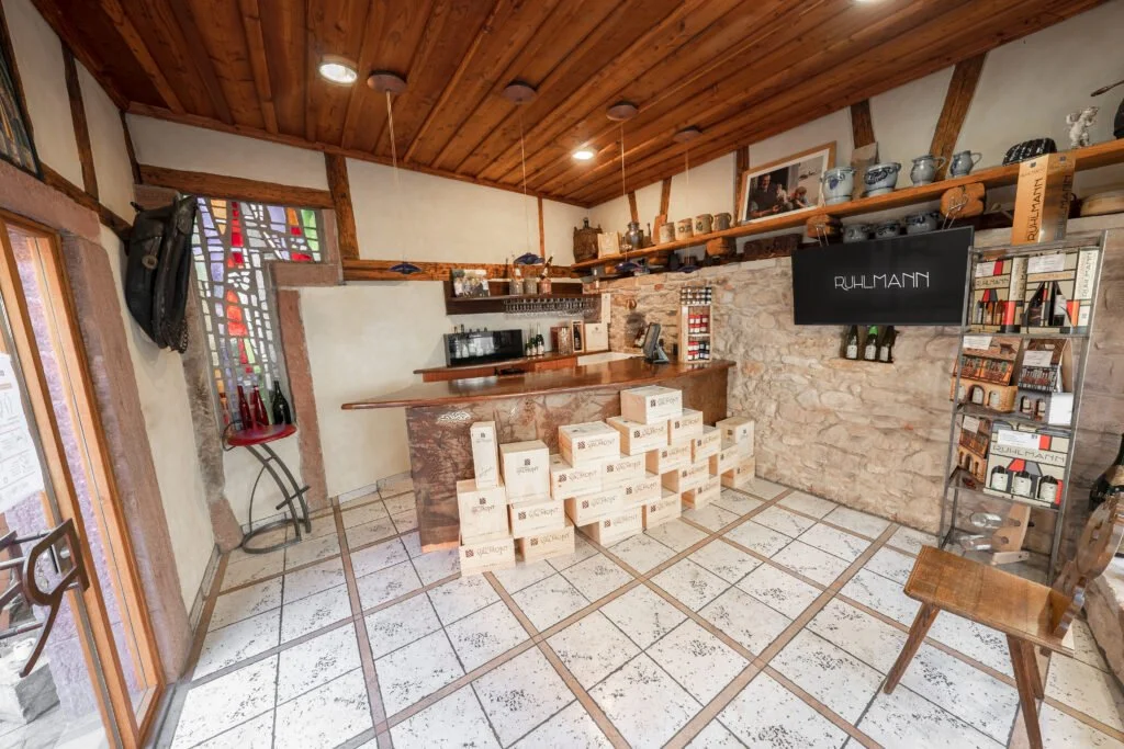 Binnenzicht van een houten bar met dozen op de vloer en een tv met de tekst 'Ruhlmann' bij het chateau van Ruhlmann-Schutz