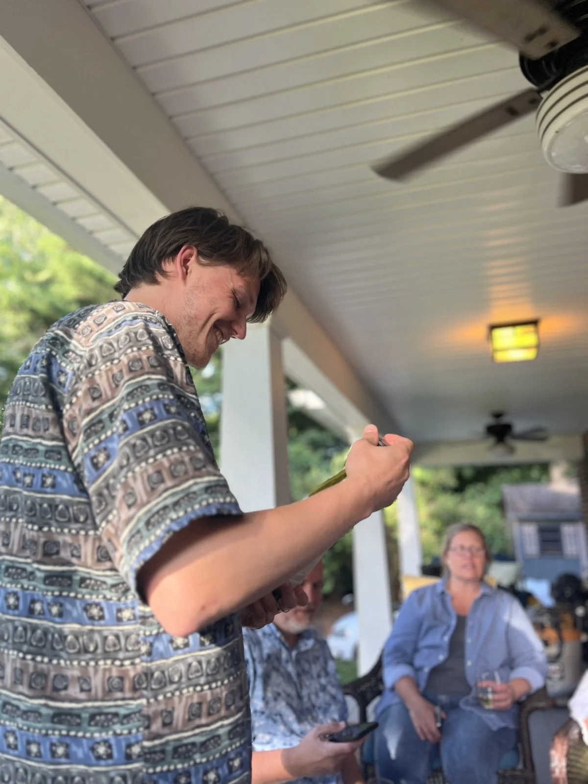 Foto van een wijnproeverij. De eigenaar van Vino by Palazzo kijkt lachend naar een fles tijdens een wijnproeverij.