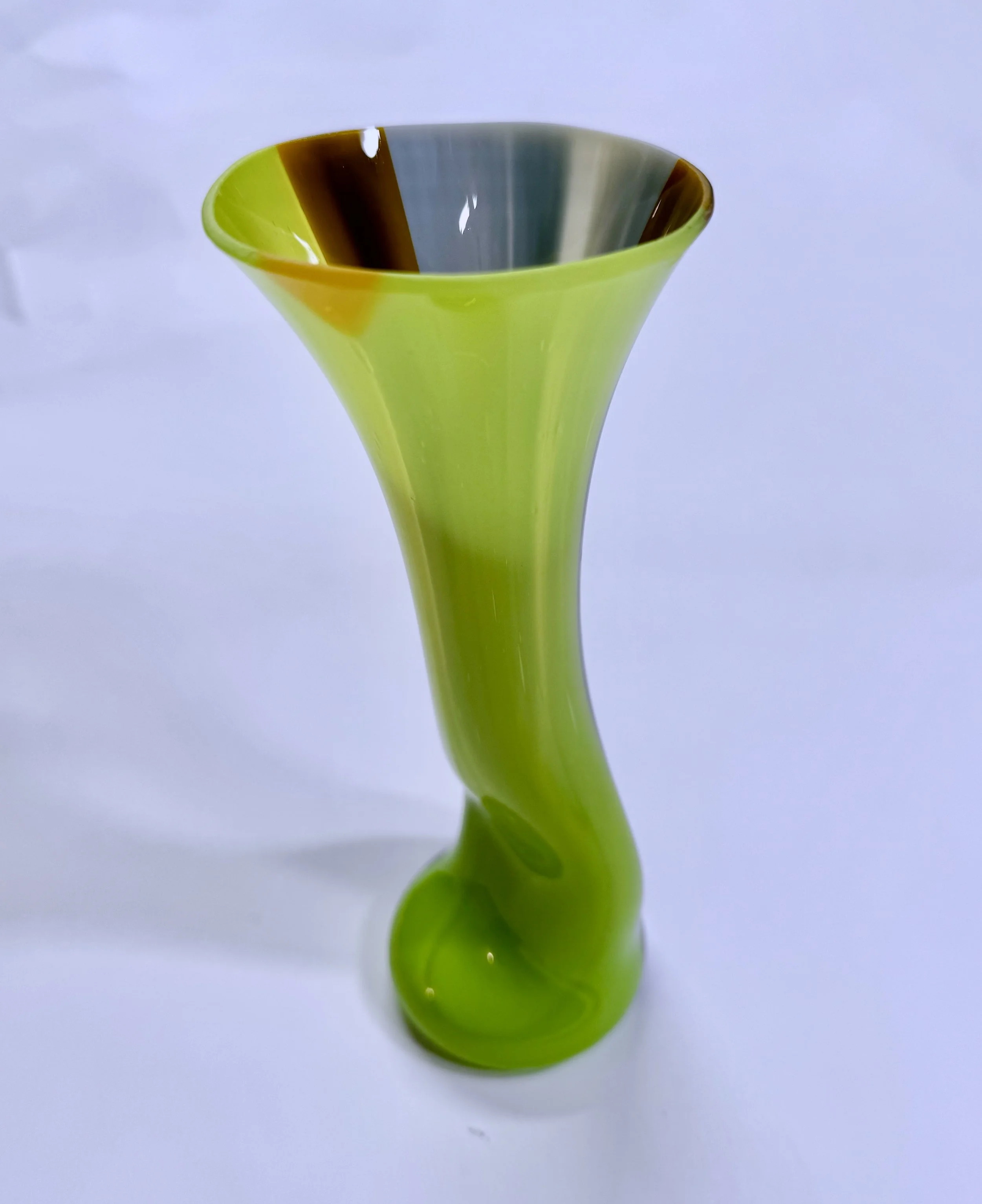 Green and black decorative glass vase with a spiral design, against a white background.