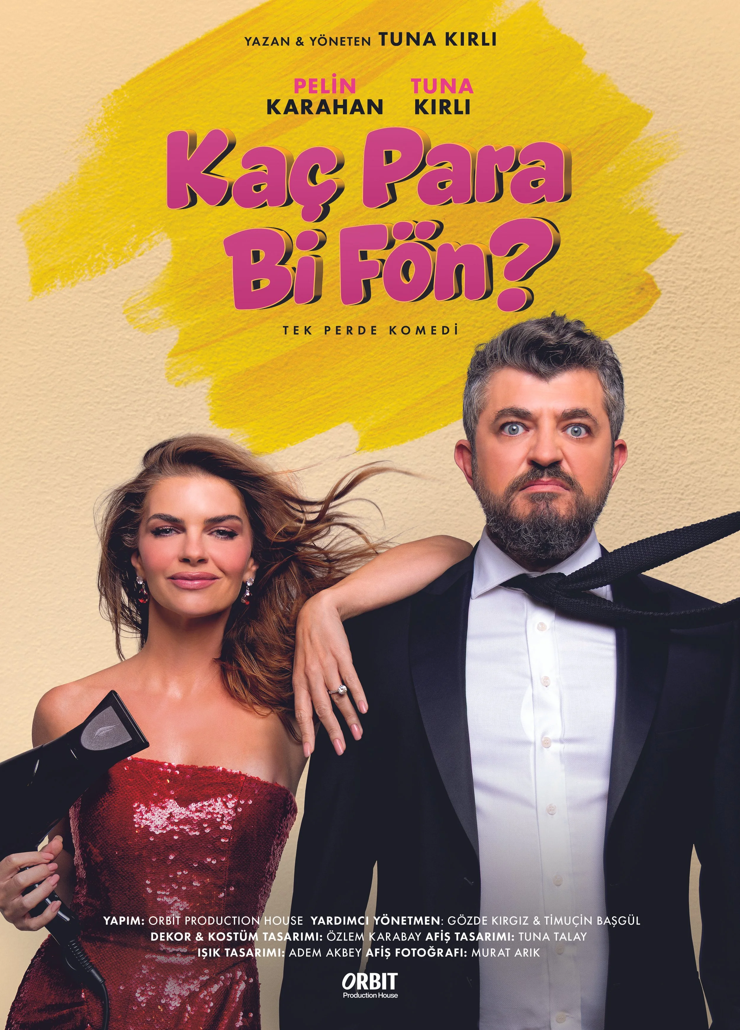 Poster for a Turkish comedy play titled 'Kaç Para Bi Fön?' featuring a woman in a red dress holding a hairdryer and a man in a tuxedo with a loose bowtie, standing against a yellow background with pink and black text.