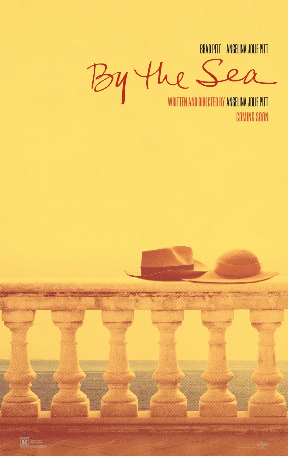 A poster for the movie "By The Sea" featuring two hats resting on a stone balustrade against a yellow background, with text indicating stars Brad Pitt and Angelina Jolie Pitt, and that it is written and directed by Angelina Jolie Pitt, coming soon.