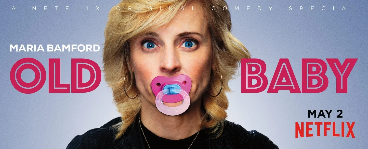 Promotional poster for the Netflix comedy special titled 'Old Baby' featuring Maria Bamford. The poster shows Maria Bamford with blonde hair, blue eyes, and wearing a black top with a pink pacifier in her mouth. The text includes her name, the title 