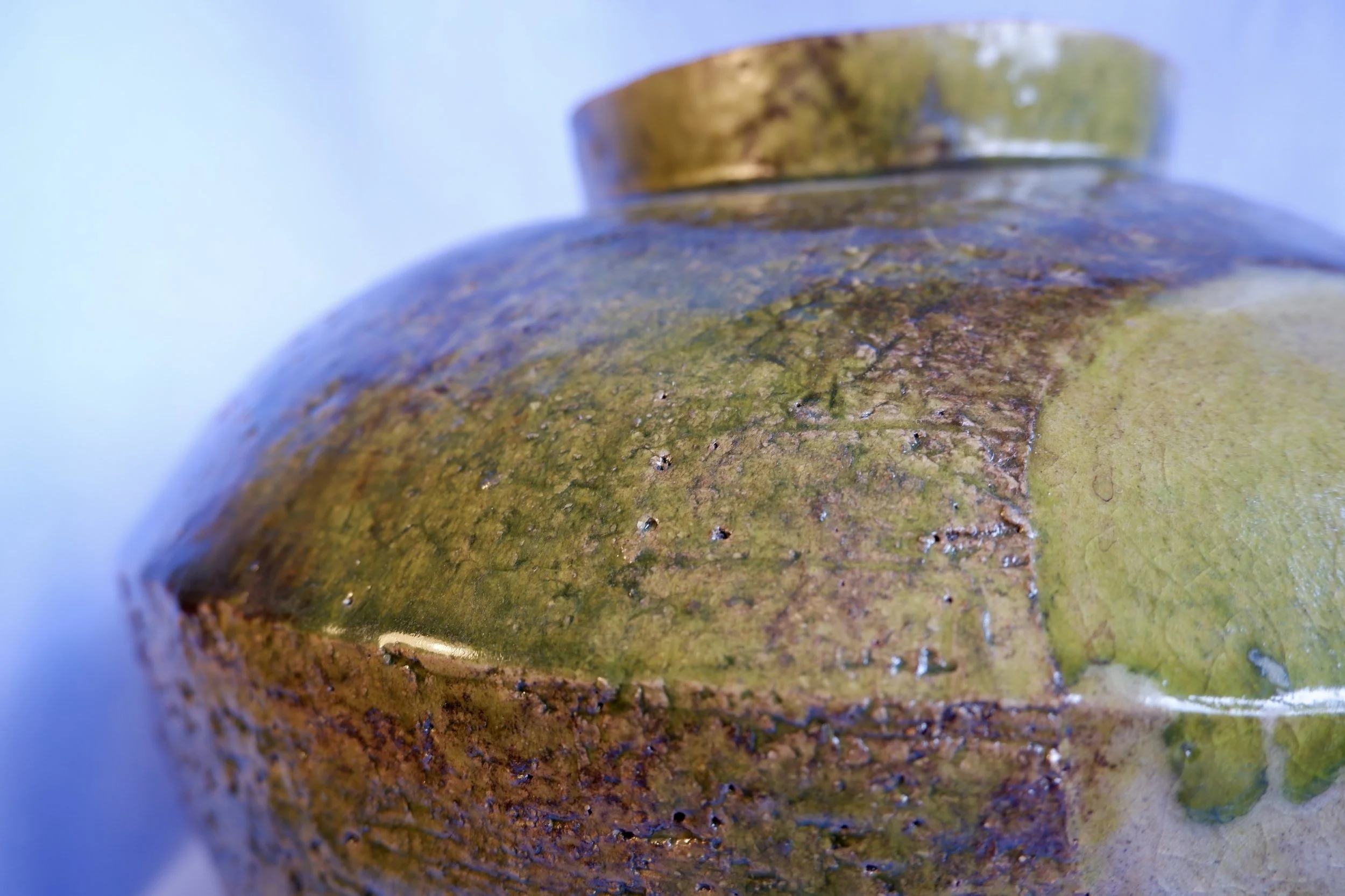 Big vase made from red clay, glazed in shades of green and brown.