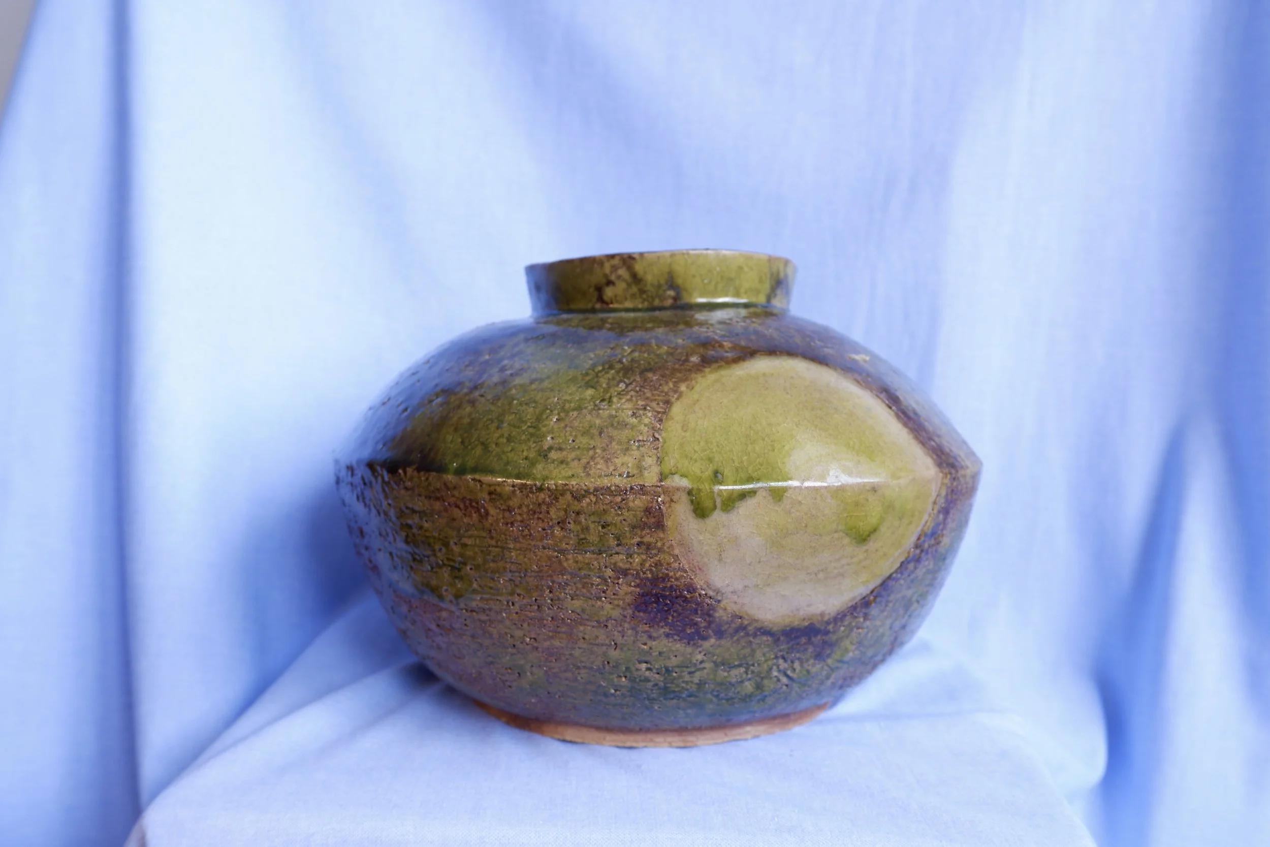 Big vase made from red clay, glazed in shades of green and brown.