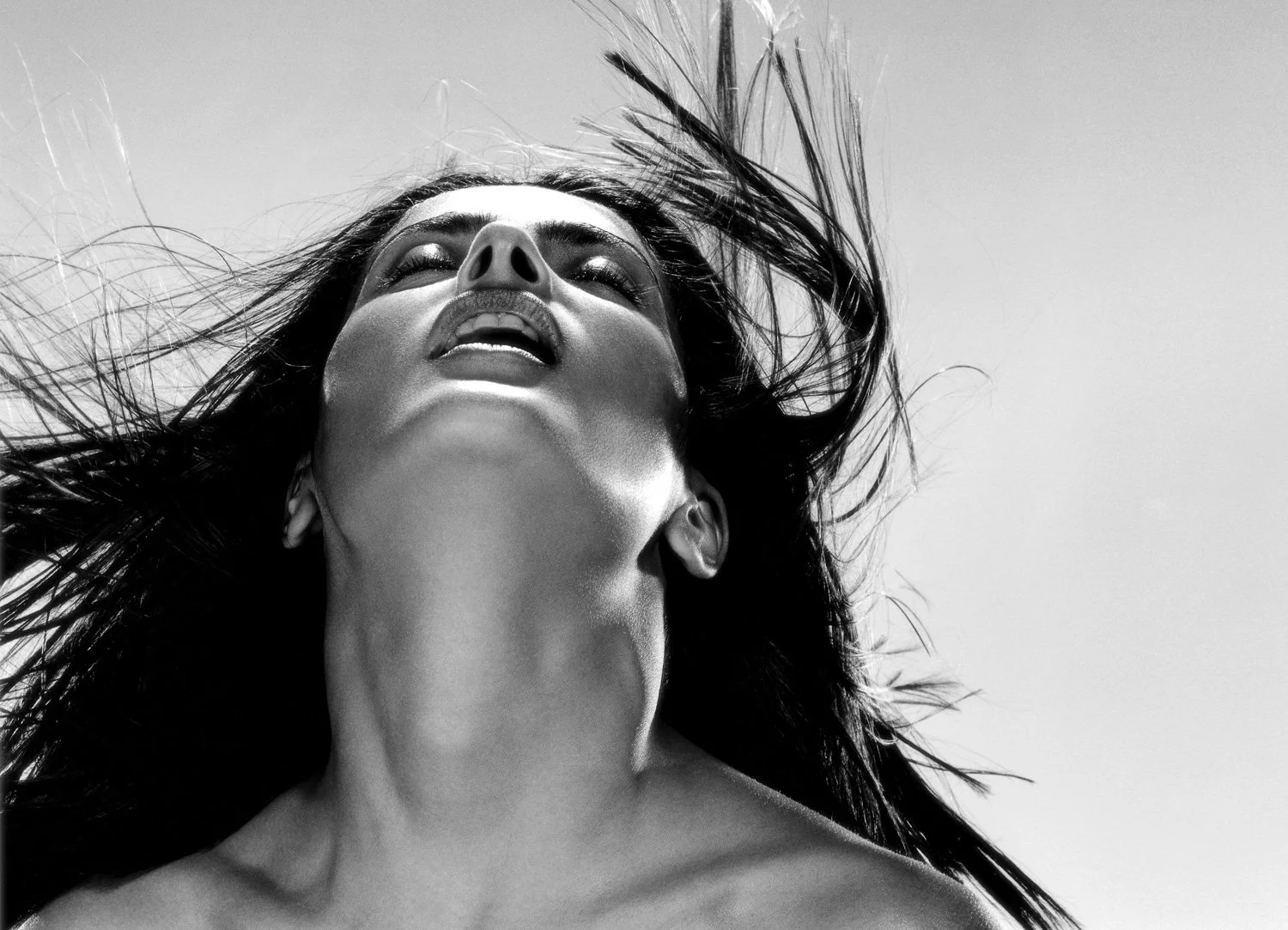 SALMA HAYEK with her head tilted back and long hair flowing, captured in black and white, with her eyes closed and mouth slightly open.