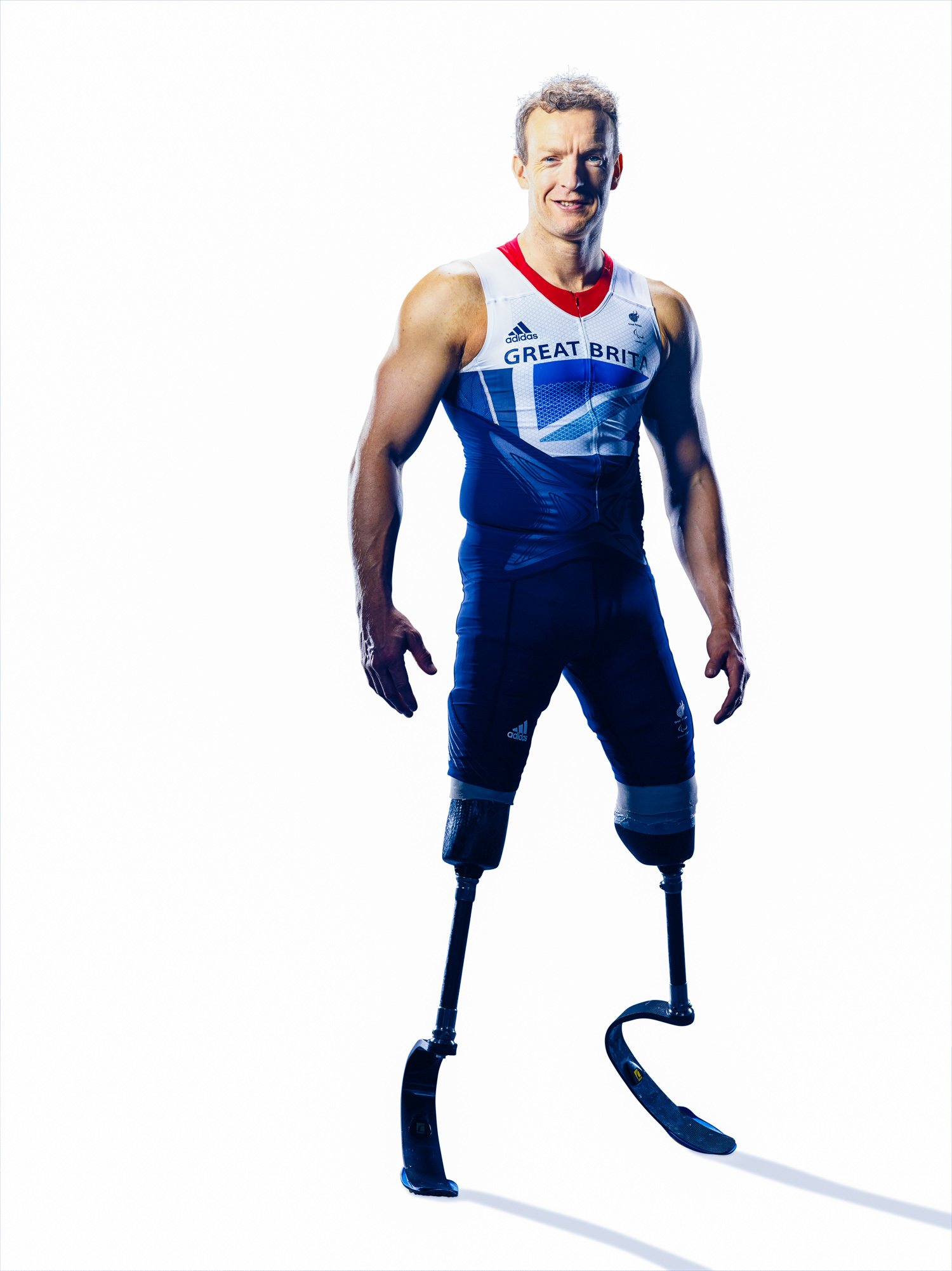 A male athlete with prosthetic legs wearing a Great Britain athletic suit, standing with a confident expression.