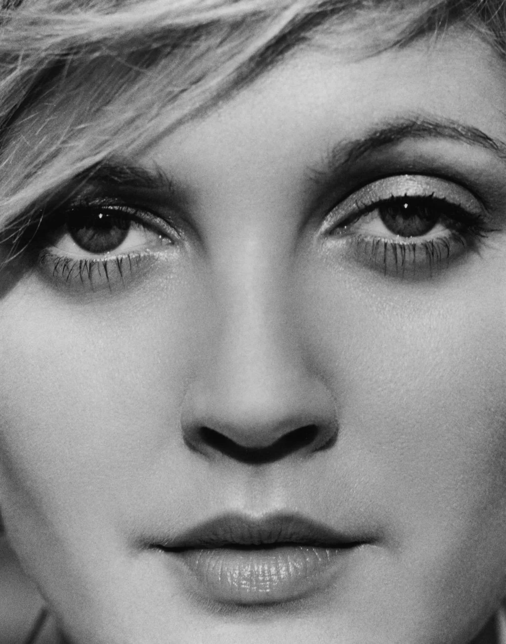 Close-up black and white photo of aDREW BARRYMORE, focusing on her eyes, nose, and lips.