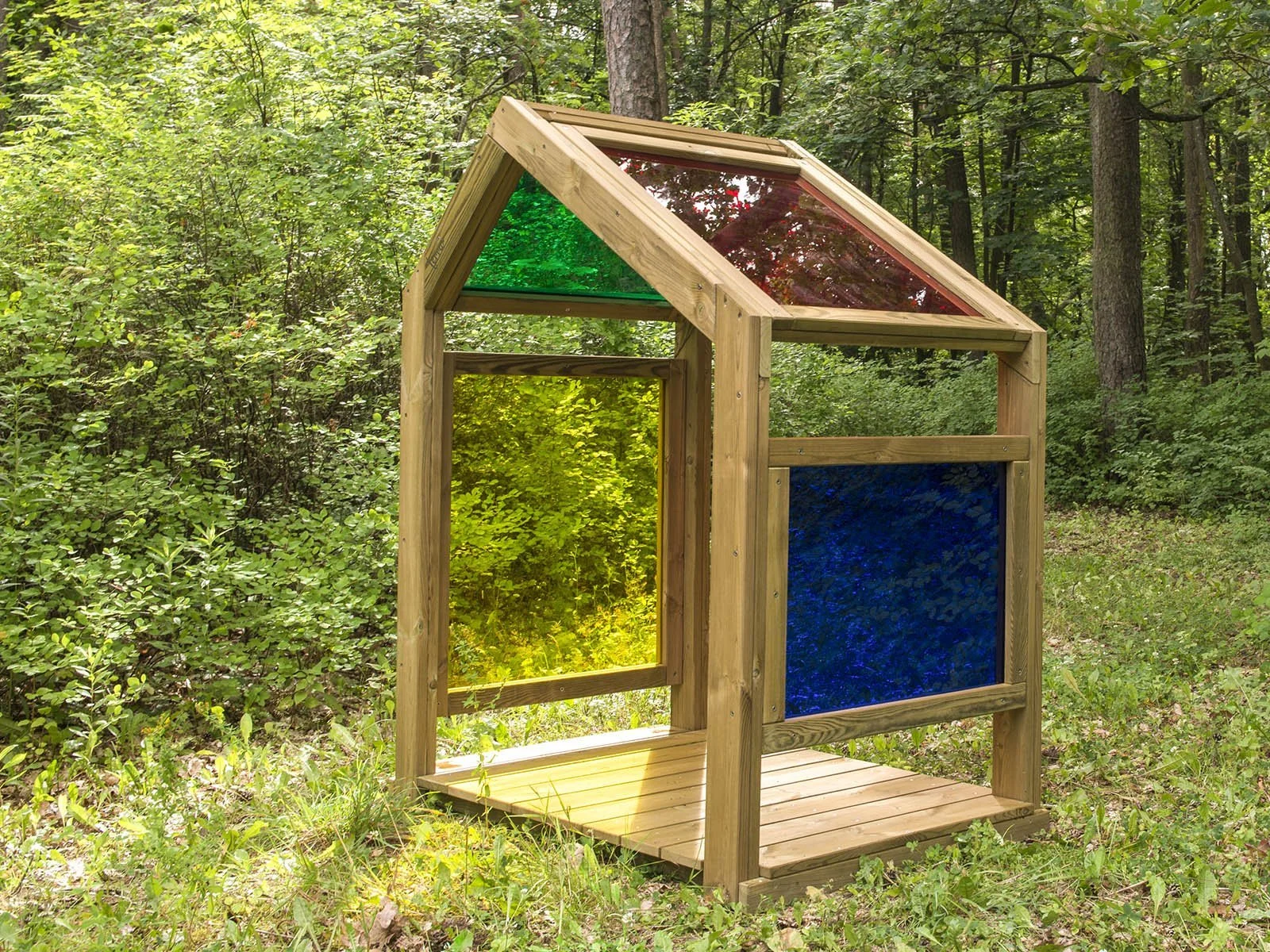 Natural wooden sensory playhouse with colorful acrylic panels, designed for children aged 1–7 to explore light, color, and imaginative play outdoors.