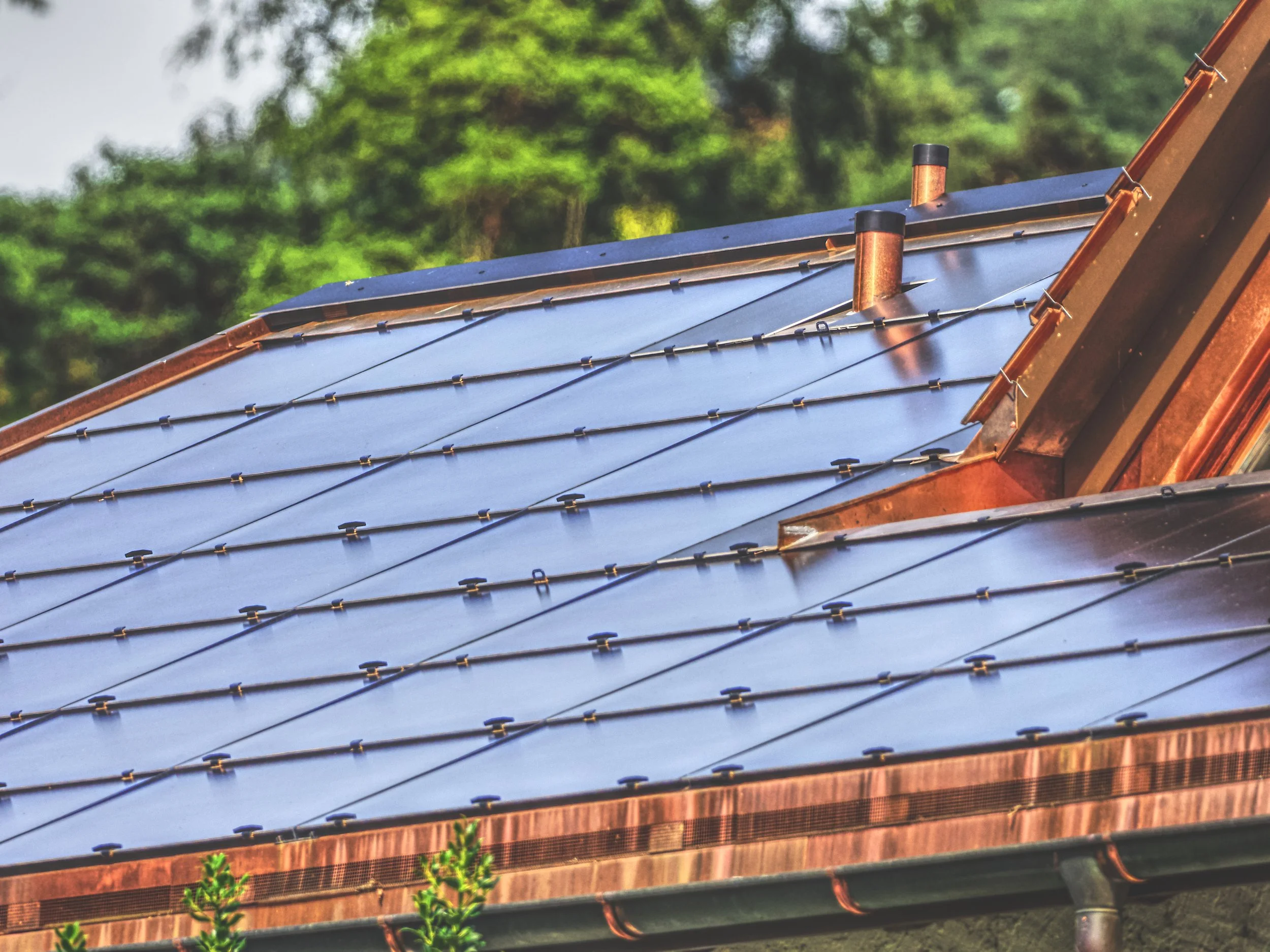 Brennende zerlegte Solaranlage auf einem Dach mit Blick auf bewaldetes Gelände im Hintergrund.