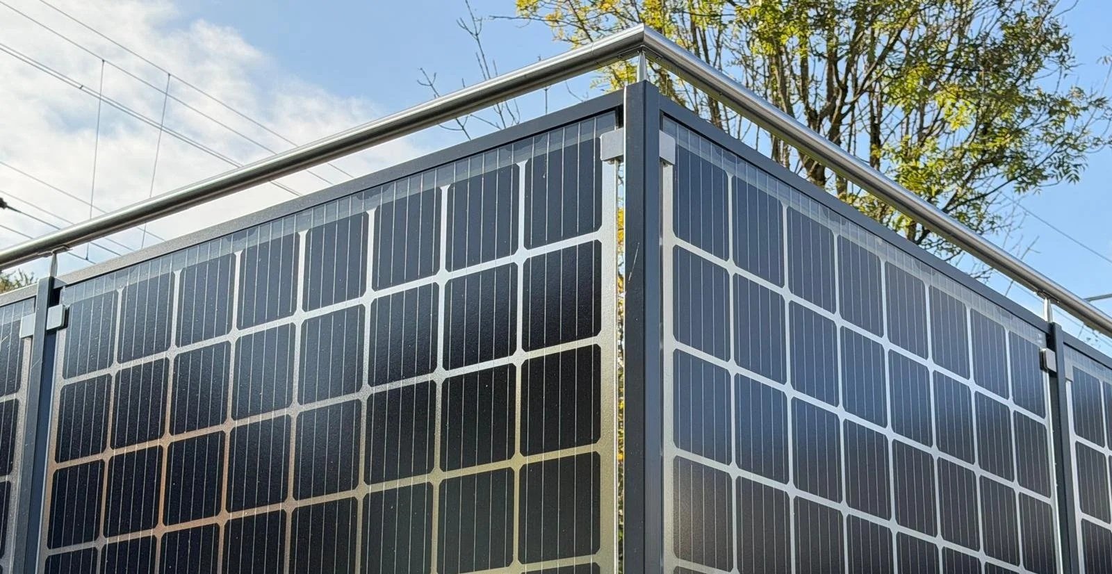 Solarzellen auf der Seite eines Gebäudes, bei sonnigem Himmel.