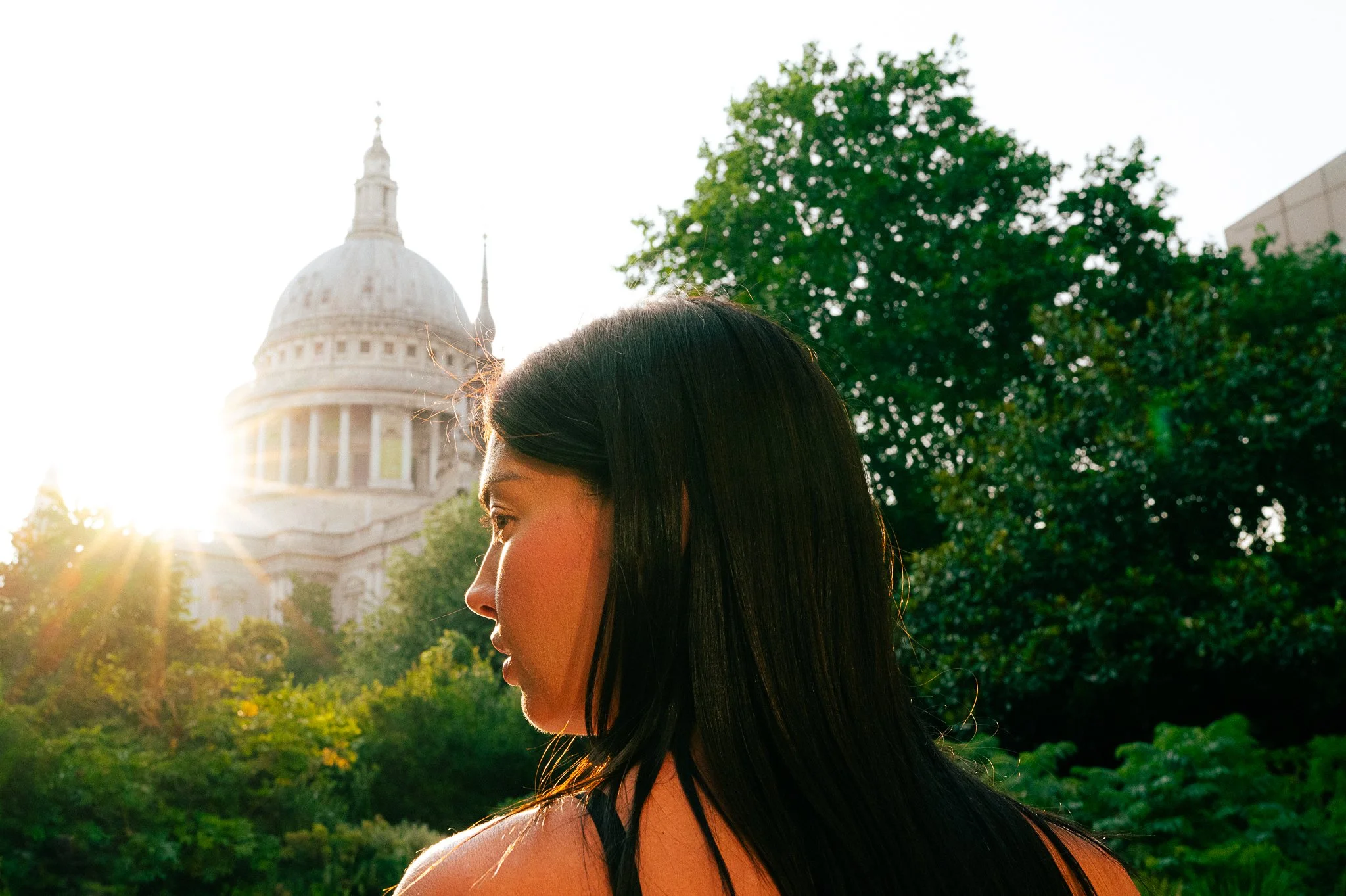 Dark haired lady at St. Paul's London, with a setting son in the background