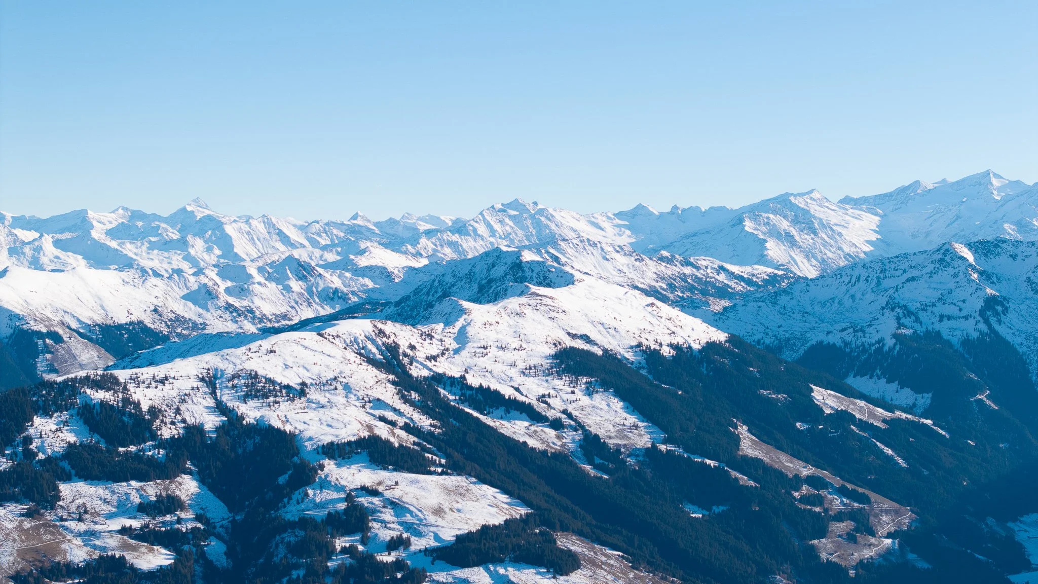 Schneebedeckte Bergkette unter klarem blauen Himmel.