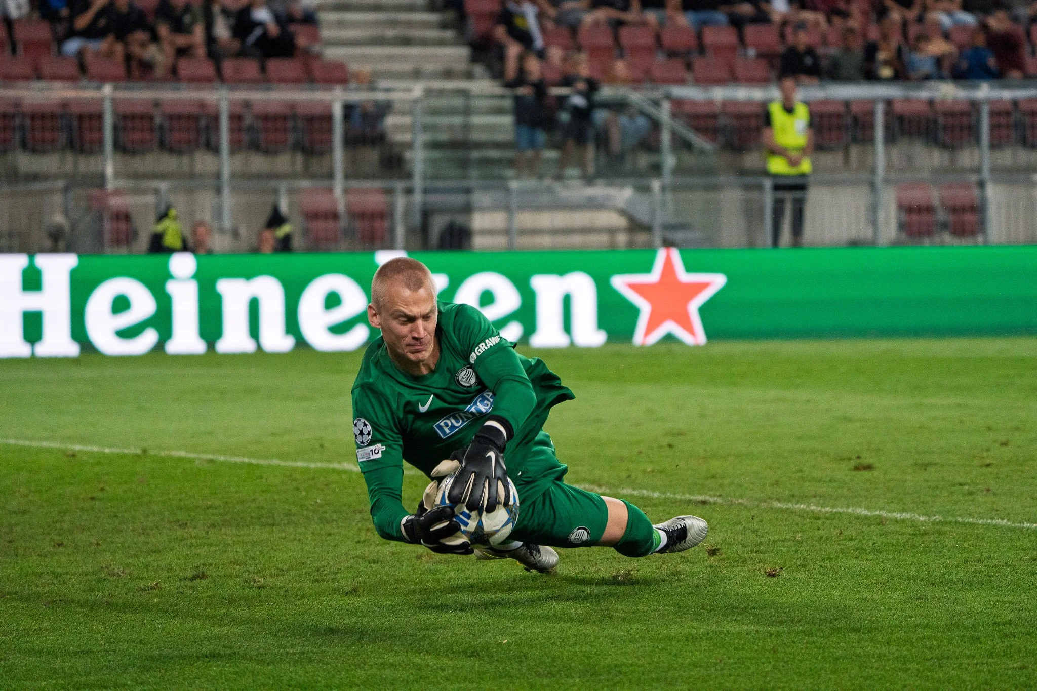 Fußballtorwart in grüner Uniform griffbereit auf dem Spielfeld