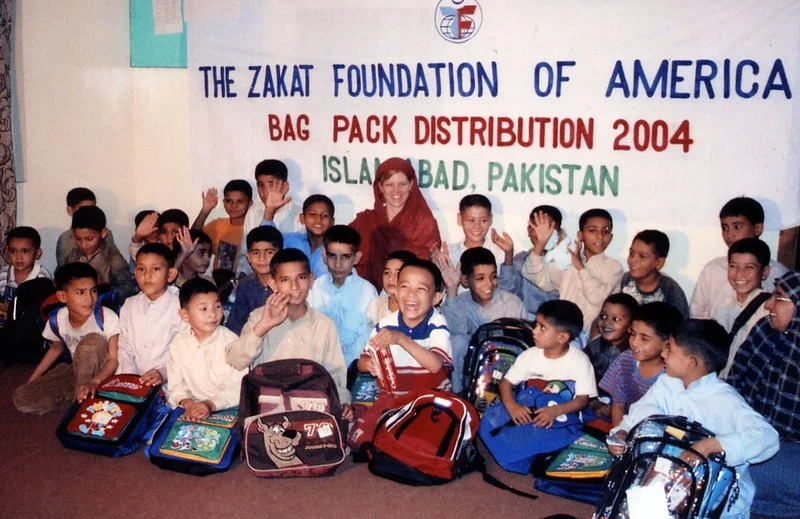 Group photo of children with backpacks at a distribution event in Islamabad, Pakistan, organized by The Zakat Foundation of America in 2004 for bag pack distribution.