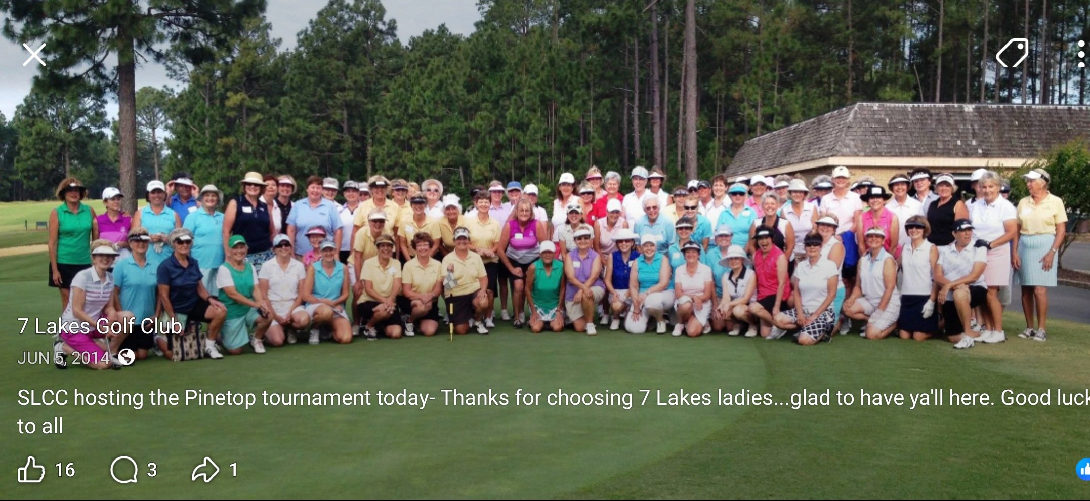 A large group of golfers gathered on the green for a team photo at Seven Lakes Golf Club