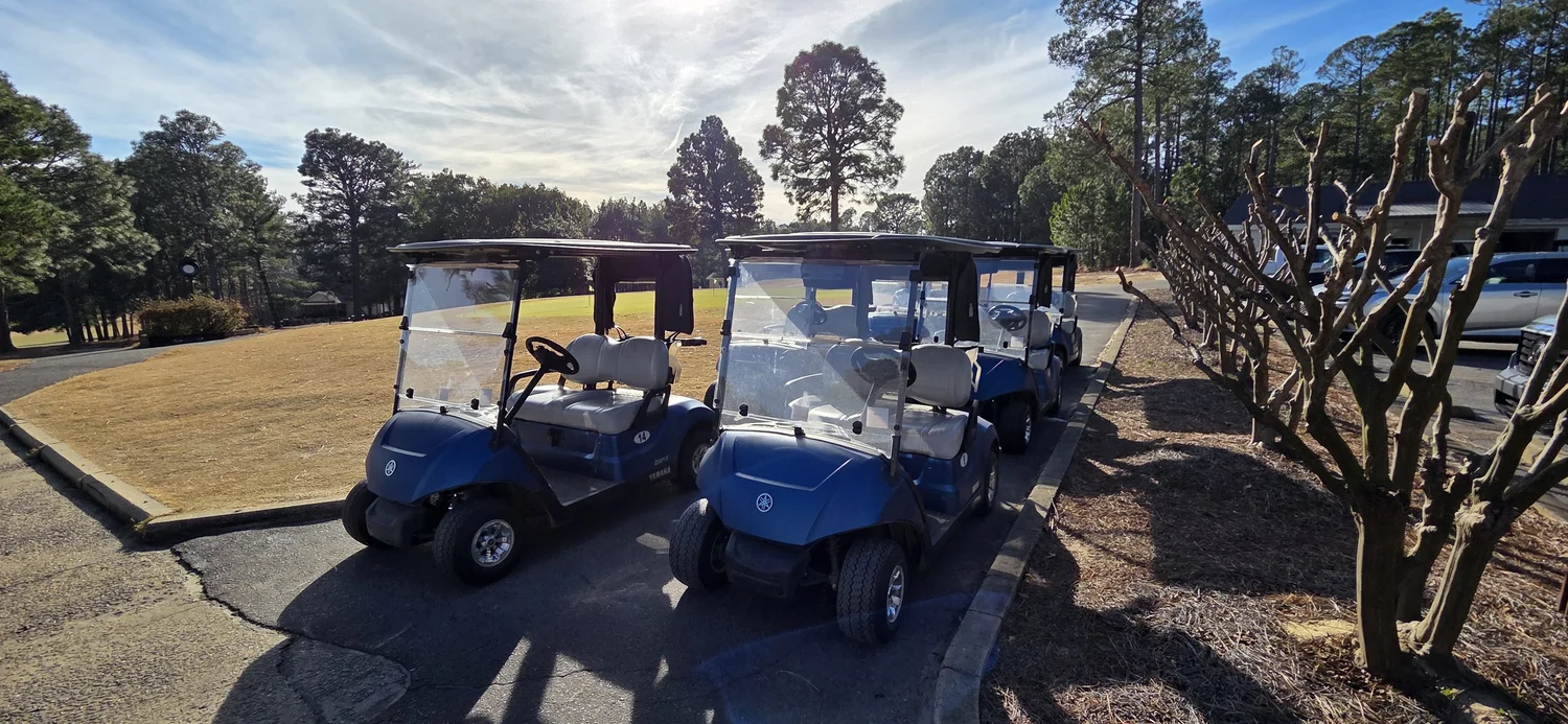 Golf carts lined up by the clubhouse at Seven Lakes Golf Club