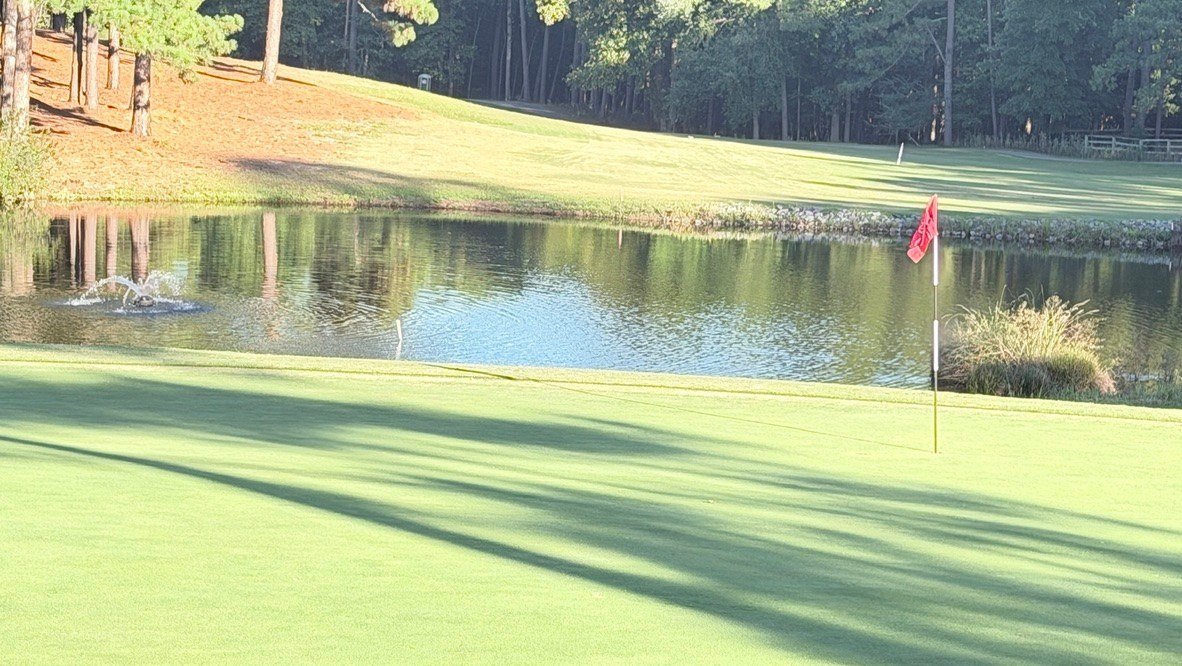 Red flag on the hole 4 green with the pond and fountain behind