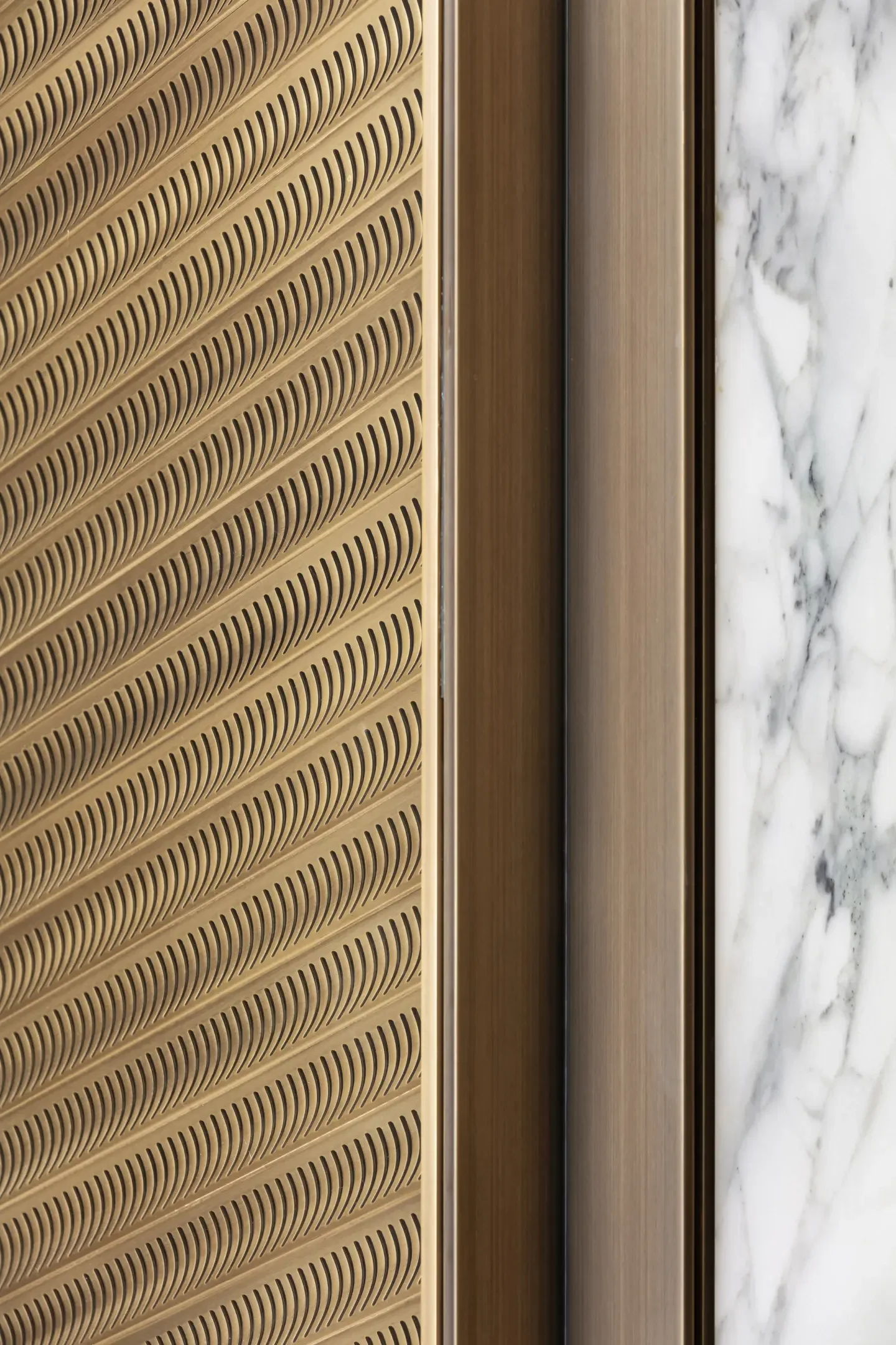 Close-up of an interior door frame with a marble wall on the right and a textured wooden panel on the left.