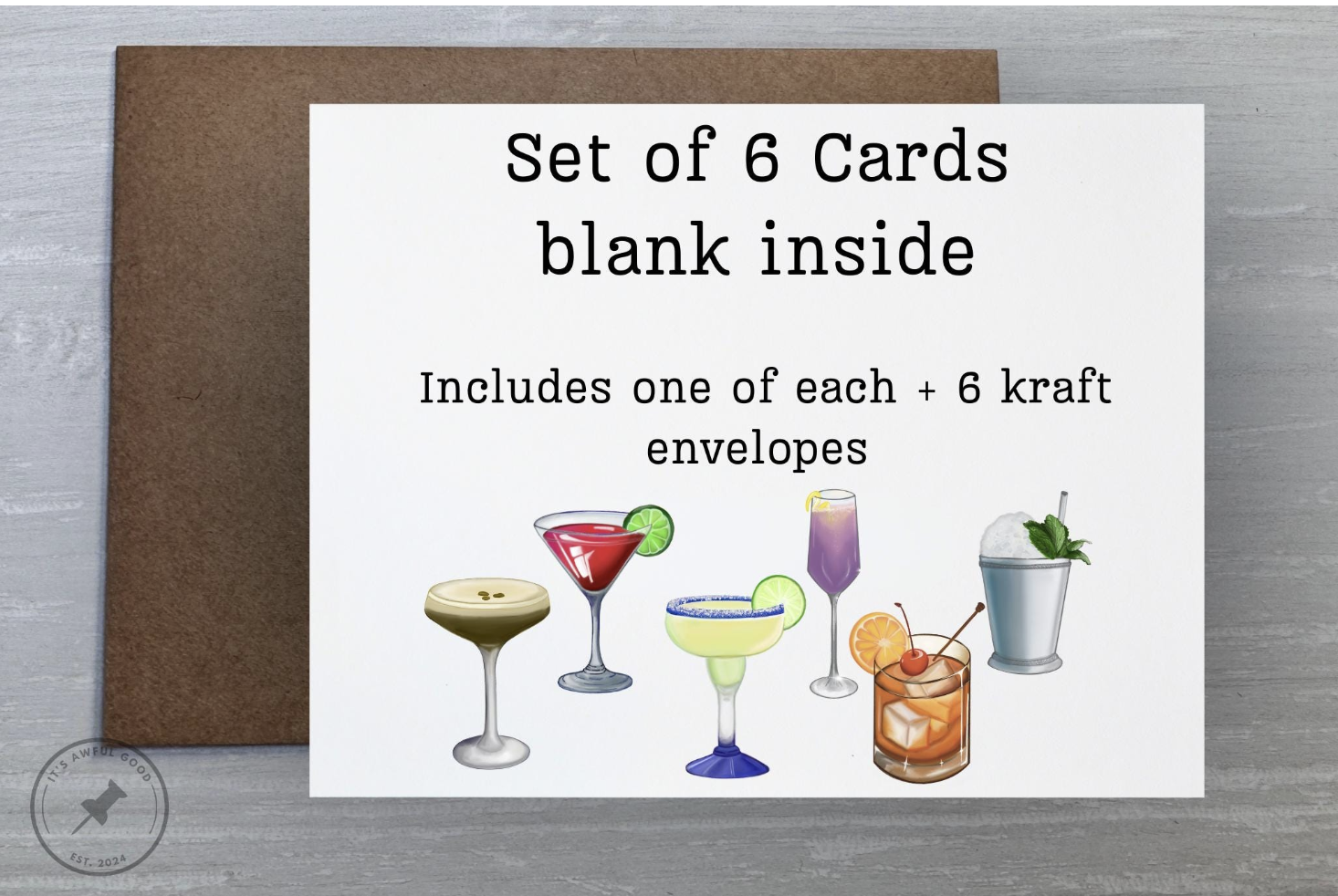 Sign advertising a set of 6 blank cards with six cocktail images at the bottom, including a lemon drop martini, cosmopolitan, margarita, mojito, Mai Tai, and piña colada, with a brown envelope behind the sign.
