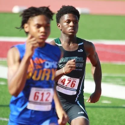 Two young male athletes running on a track during a race