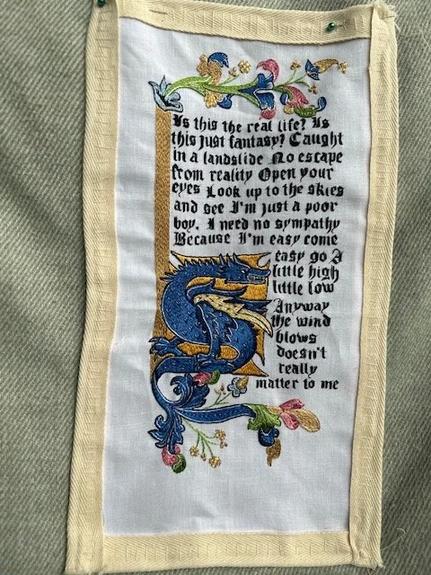 Modern embroidery drawing on medieval manuscript letterforms and script, executed entirely in silk split stitch.