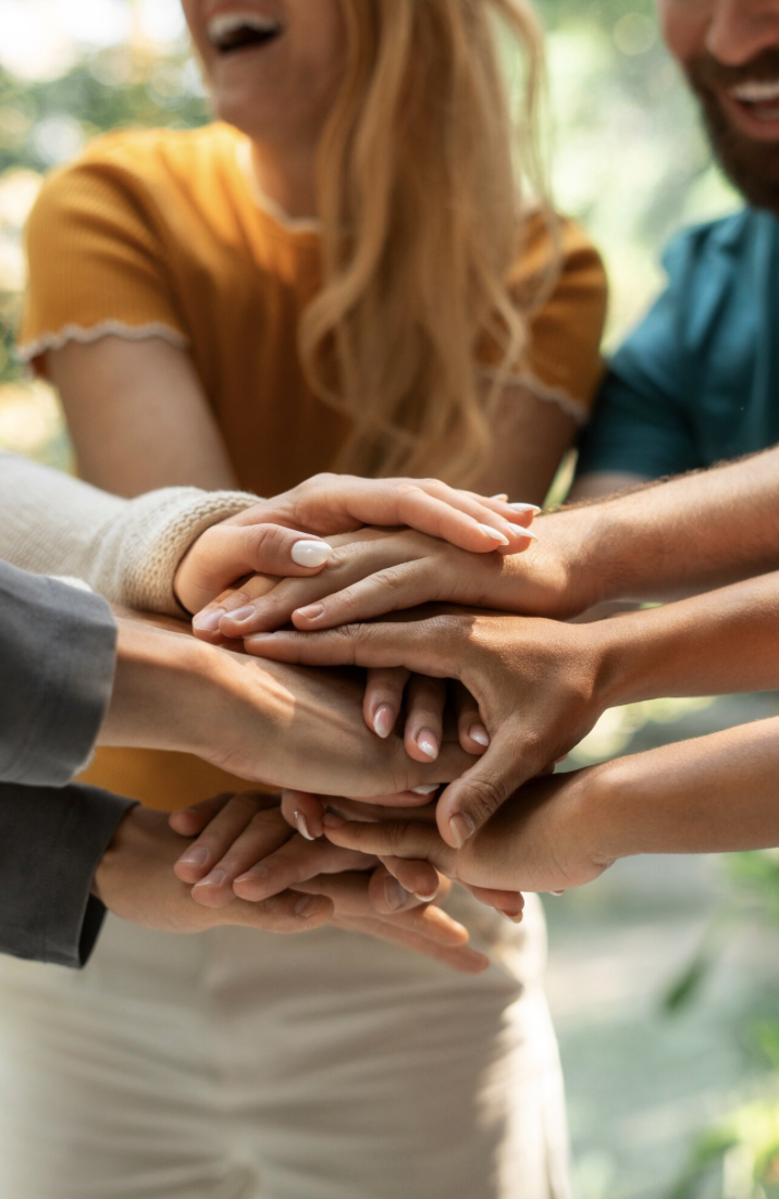 Groupe de personnes qui mettent leurs mains ensemble en signe d'unité.