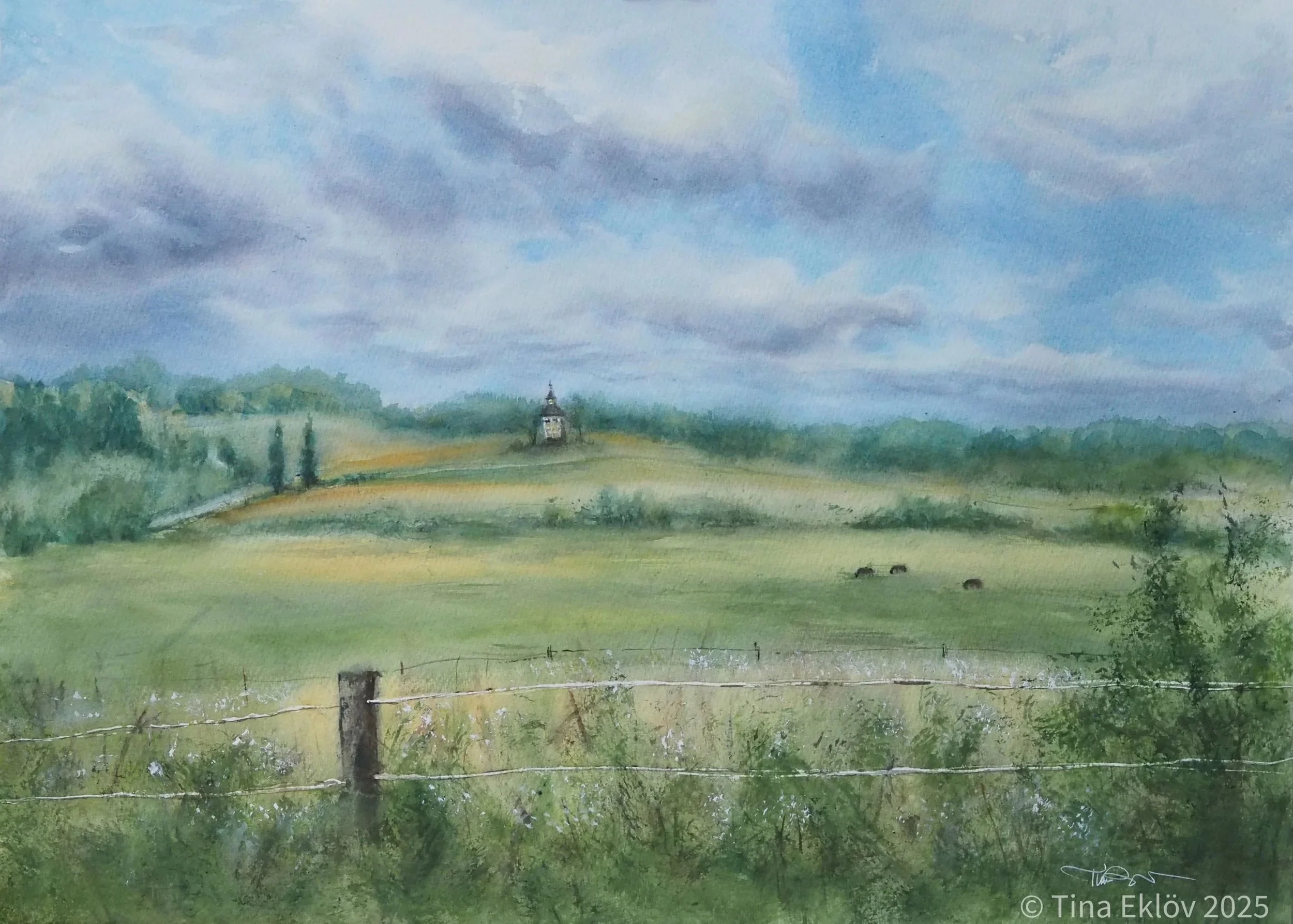 Landscape in Roslagen shows a lanscape a cloudy sommerday in Sweden. You see a clock tower in the distance.