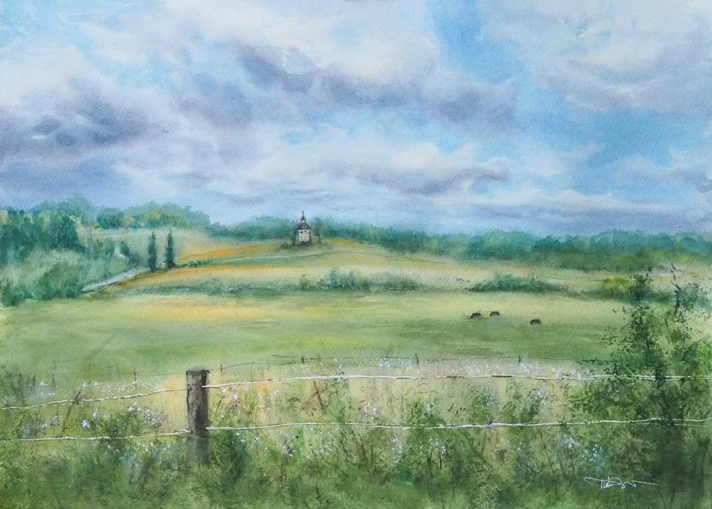 Watercolor painting of a rural landscape with a cloudy sky, green fields, a fence in the foreground, and a house or church on a hill in the distance.