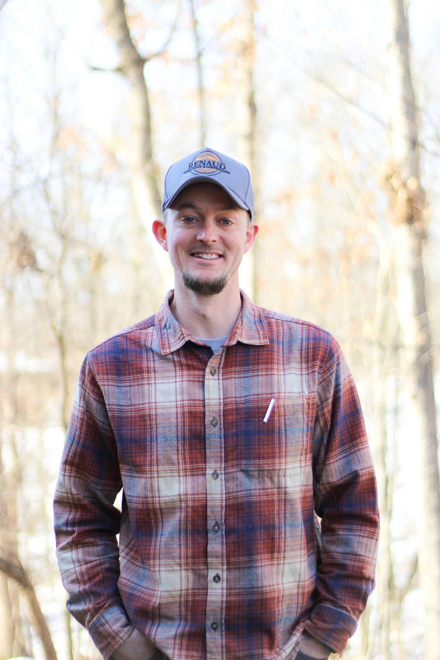 A middle-aged man with gray beard sitting on a bench in a room with neutral-colored walls, looking thoughtfully to the side.
