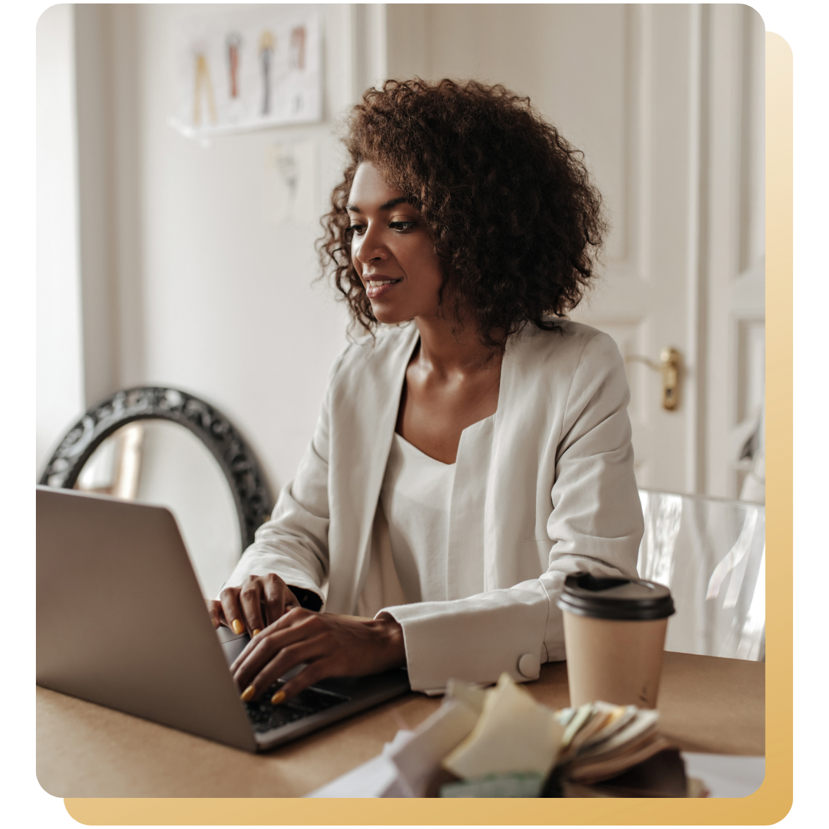 Woman working on a laptop at a desk with a coffee cup in a bright, calm workspace.