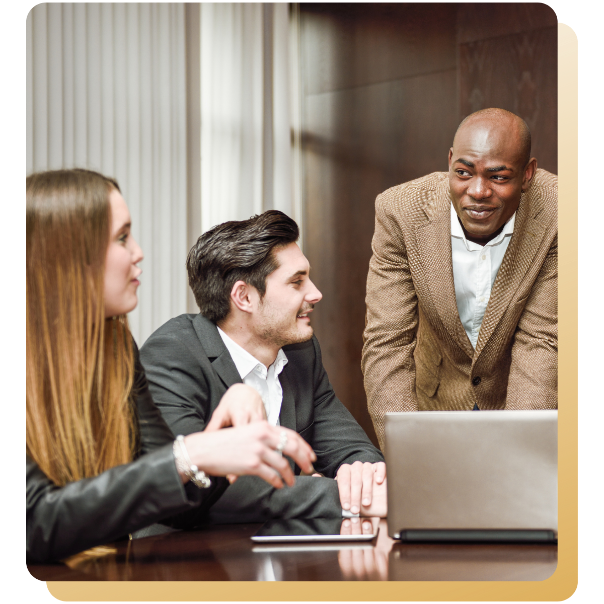 Business leader leaning forward to speak with team members during a collaborative meeting.