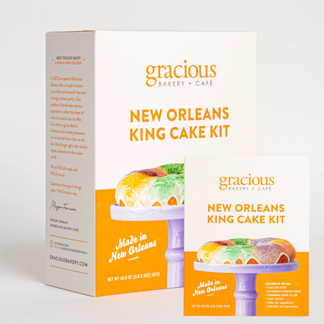 Box and card for the New Orleans King Cake Kit from Gracious Bakery + Cafe, featuring an image of a decorated king cake on a purple stand and text indicating it is made in New Orleans.