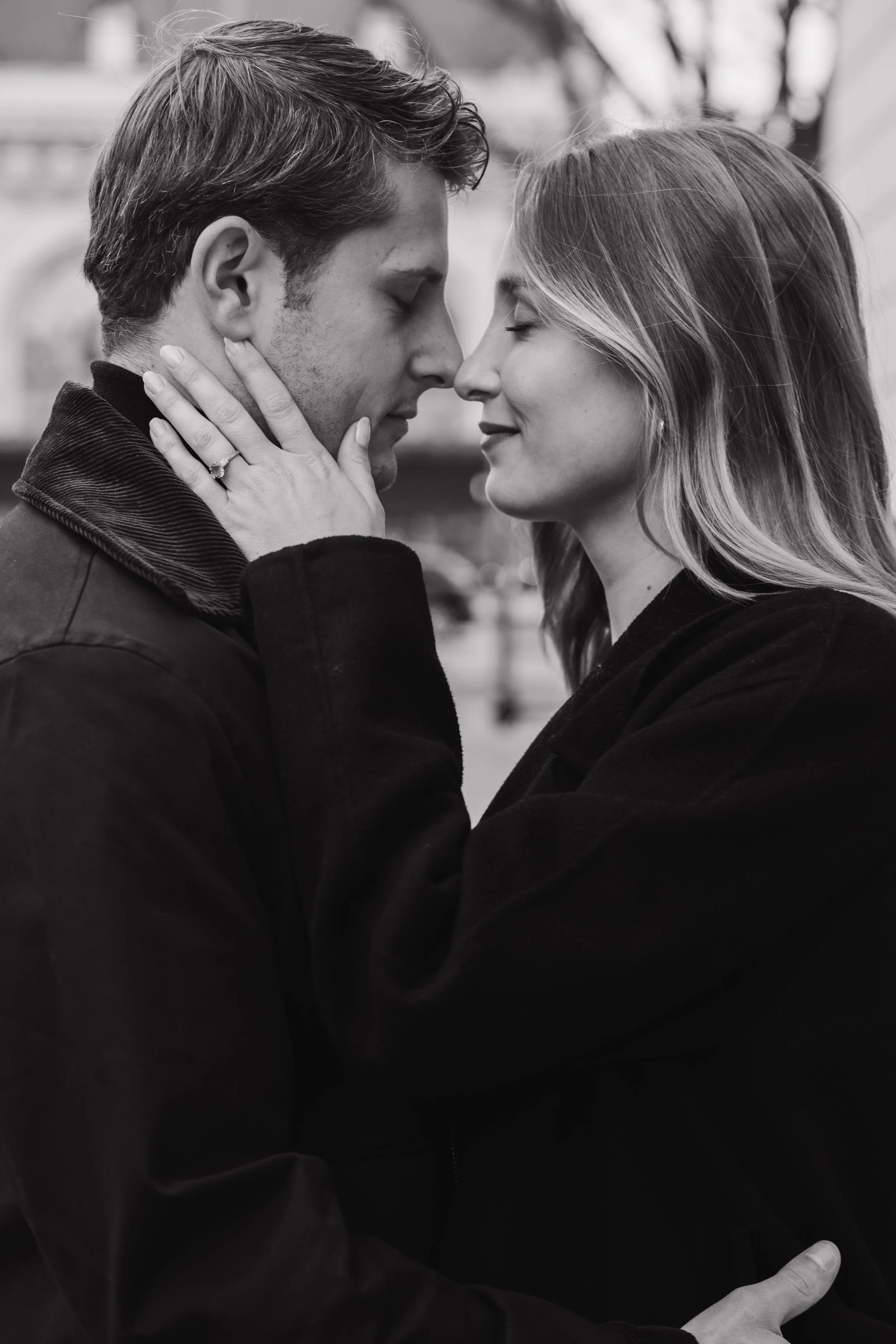 Un couple qui s'aime, s'enlace et se touche le front, dans une scène romantique, en noir et blanc, dans un environnement urbain. session engagement couple Lyon 6eme, brotteaux, photographe mariage bordeaux et Lyon et destination wedding