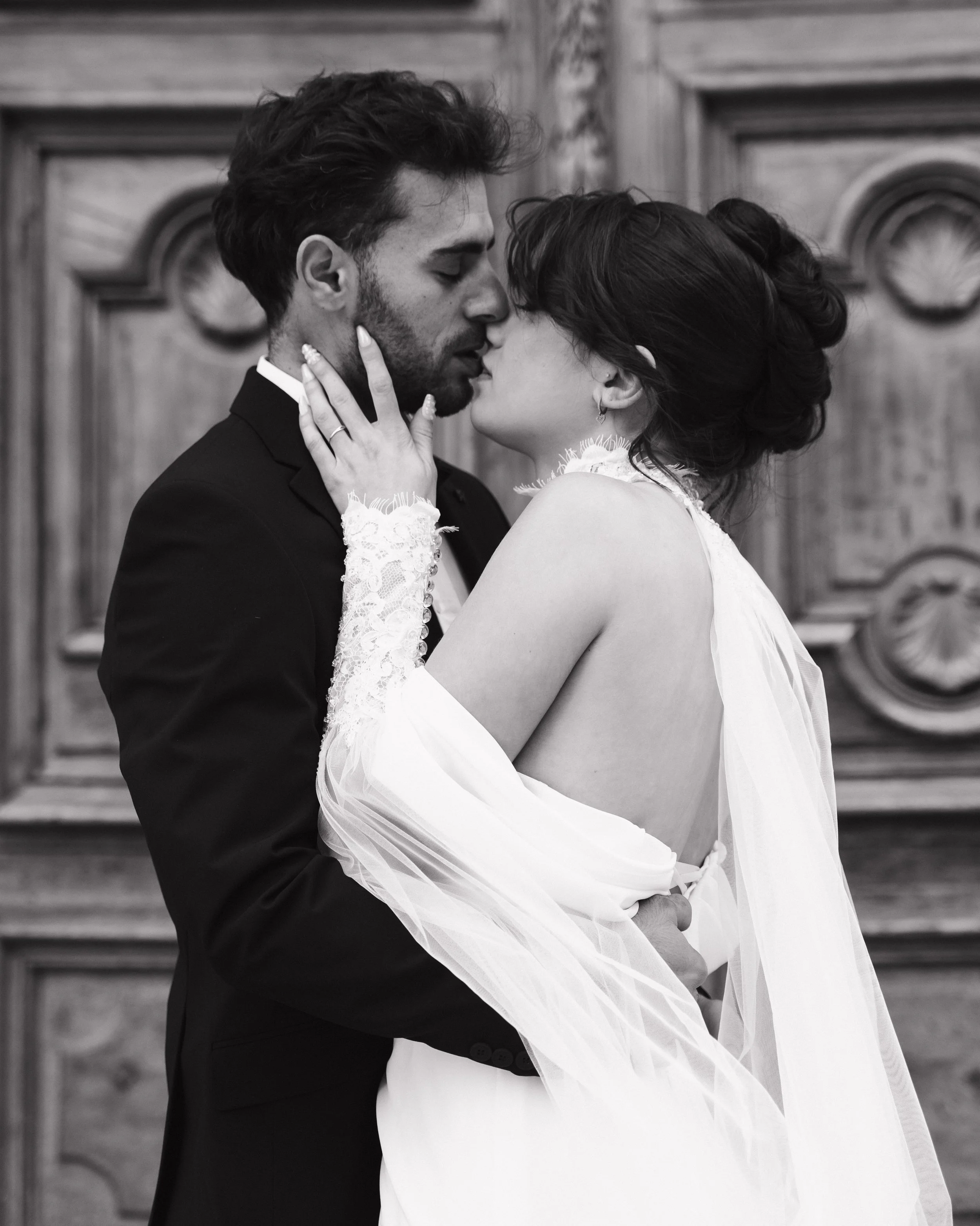 Un couple en robe de mariage s'embrassant tendrement dans une pièce avec un décor en bois sculpté à Lyon 2ème à l'hôtel dieu à l'intercontinental 