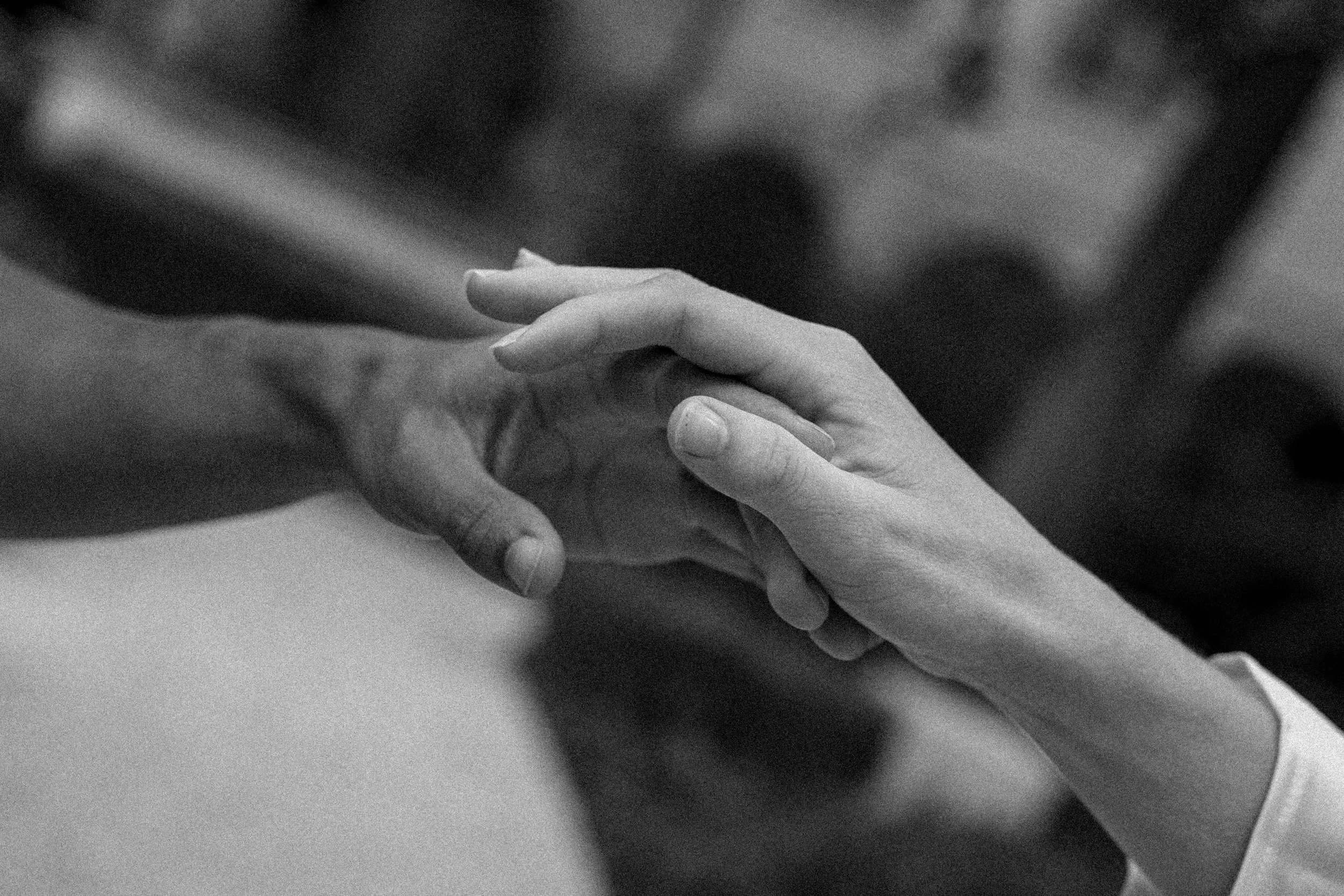 Deux mains qui se tiennent, une main féminine et une main masculine, en noir et blanc à l'hôtel dieu à Lyon 2ème, à l'intercontinental, session engament, photographe mariage duo haut de gamme.