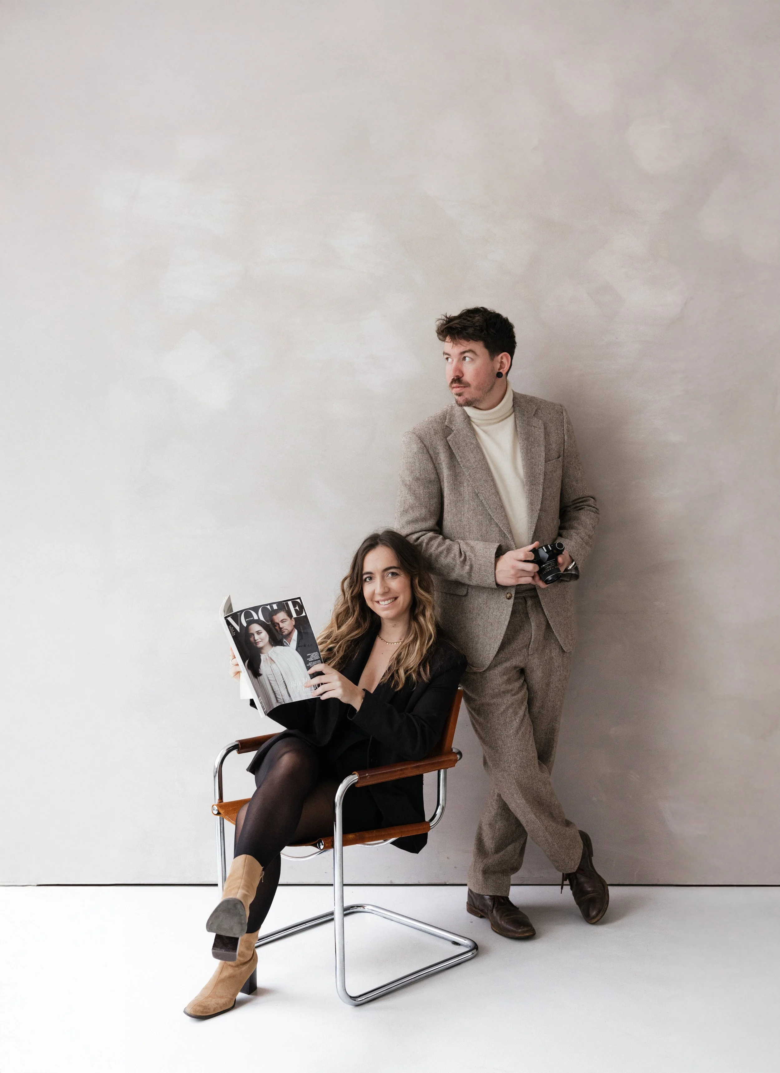 Deux photographes, une femme tenant un magazine vogue et un homme tenant un appareil photo argentique dans un studio de photo à Lyon