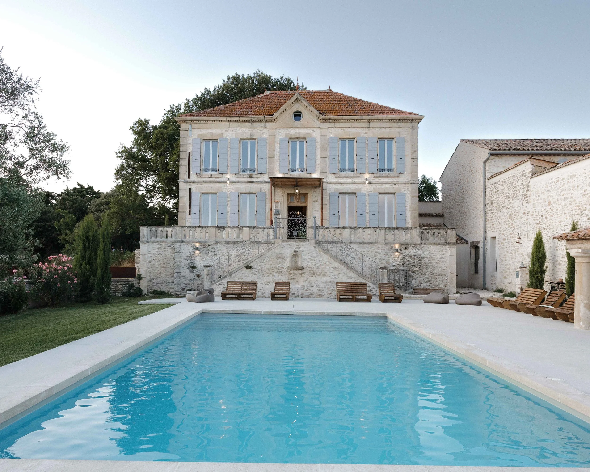 Villa en pierre avec piscine et chaises longues en extérieur. Domaine du bijoutier à grignan, drome provençal, coucher de soleil, session couple, mariage religieux, cérémonie religieuse 