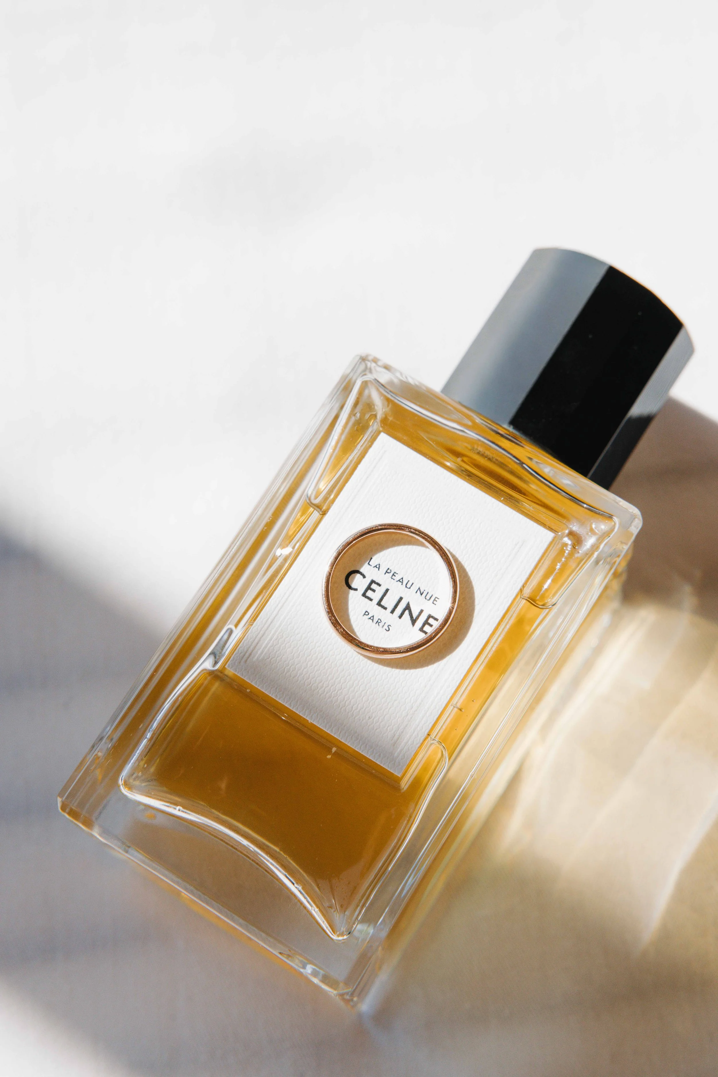 Flacon de parfum Céline La Peau Nue, vu de dessus, posé sur une surface claire, avec une lumière naturelle.