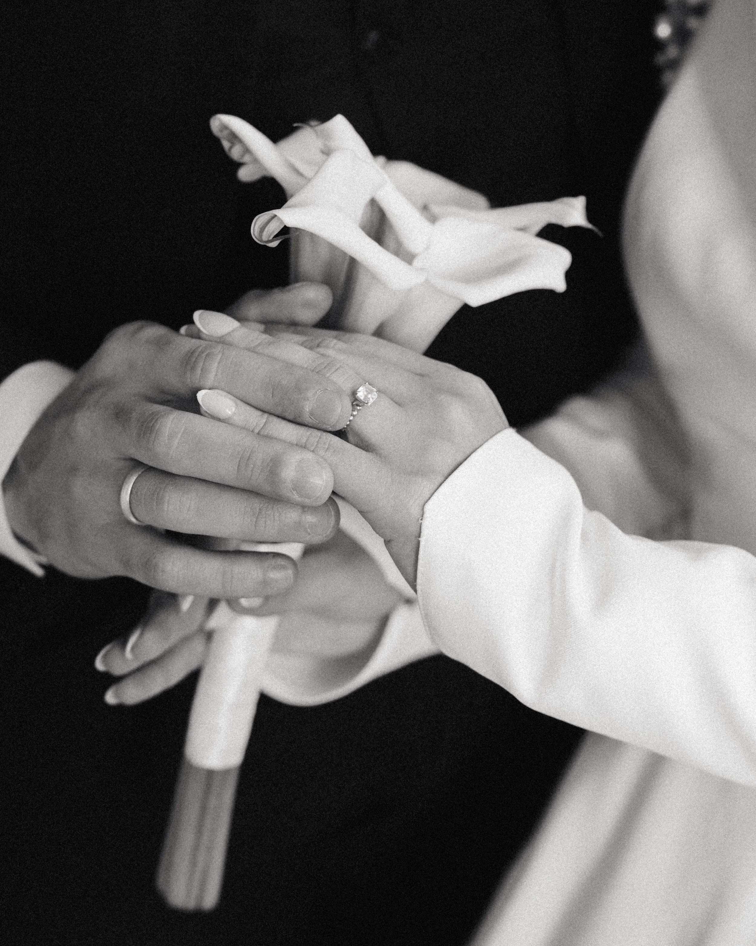 Deux mains portant des alliances, tenant une orchidée blanche, lors d'une cérémonie nuptiale. Bouquet de fleur de mariés, session engagement et mariage à l'hôtel dieu, intercontinental, Lyon 2eme. Mariage arabe