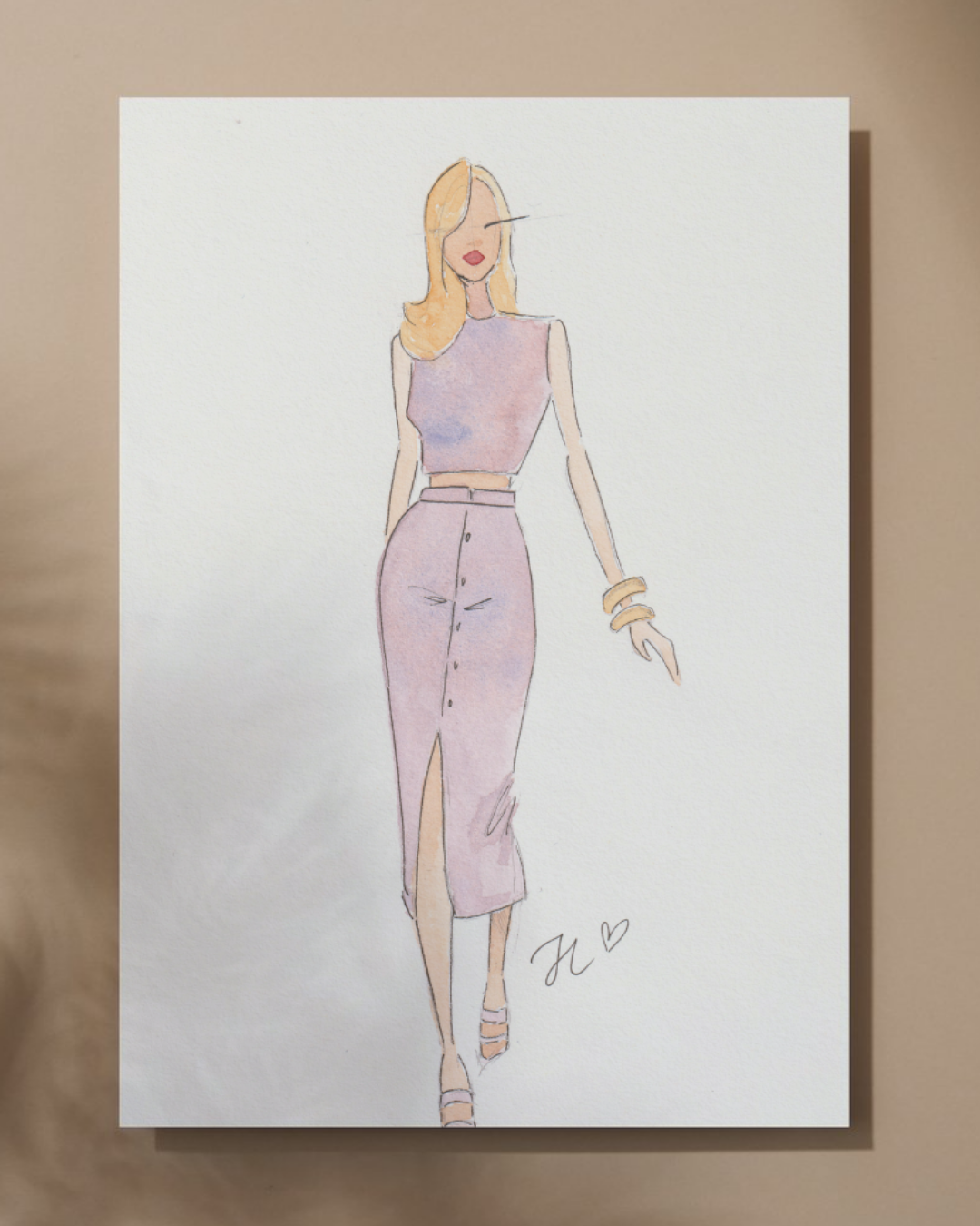 Watercolor illustration of a woman with blonde hair in a pink sleeveless top and high-waisted pink skirt, accessorized with bracelets and wearing heels. Signature with initials and a heart.