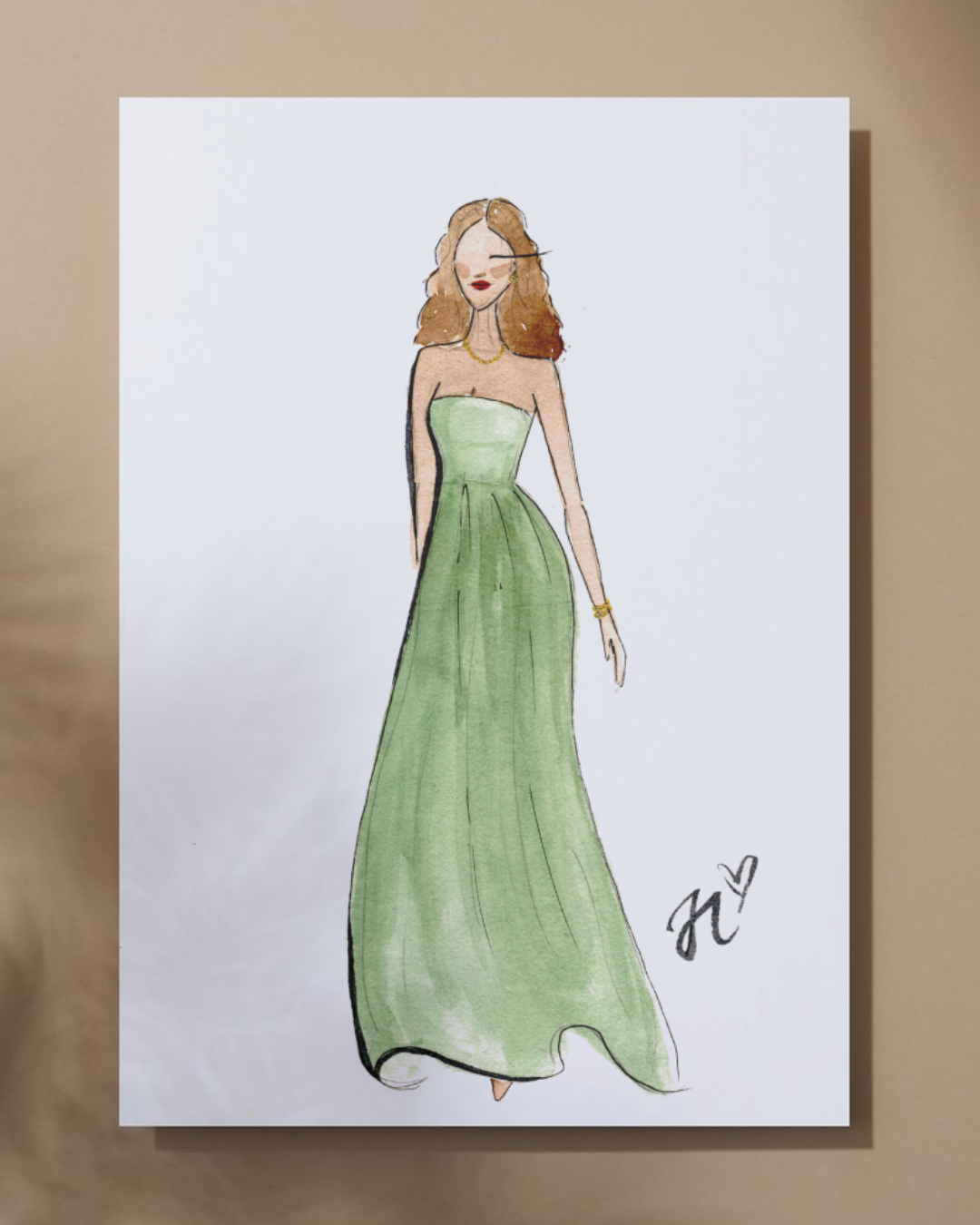 Watercolor fashion illustration of a woman in a strapless green evening gown, with red hair and jewelry, signed with initials and a heart.