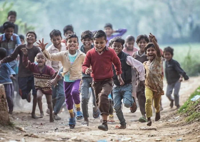 Group of children running and playing outdoors, smiling and having fun.